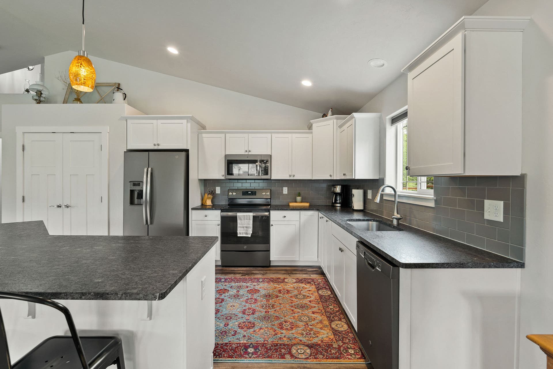13404 Crescent Moon Drive, Bigfork, MT 59911 Modern kitchen boasting crisp white cabinetry, tile backsplash, and sleek countertops