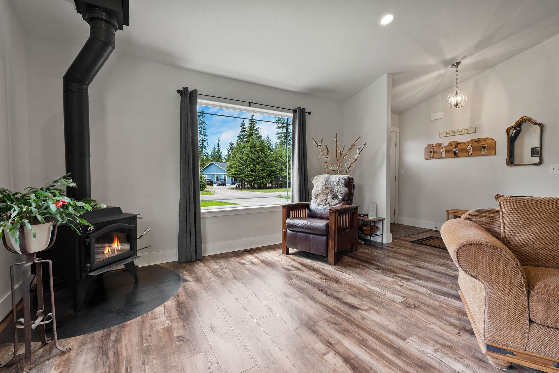 13404 Crescent Moon Drive, Bigfork, MT 59911 Light-filled great room featuring a cozy wood stove and scenic window views