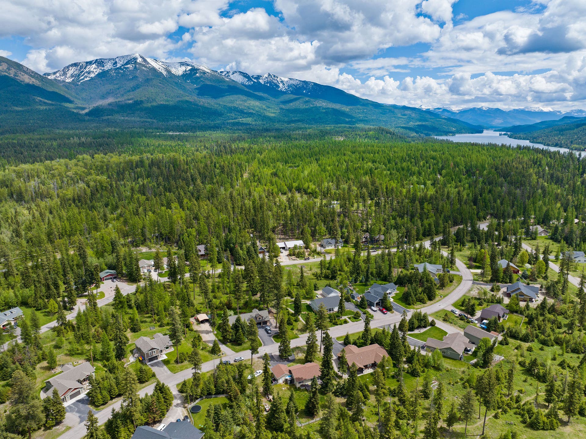 13404 Crescent Moon Drive, Bigfork, MT 59911 Breathtaking neighborhood view showcasing the lush forest canopy, Swan Lake and the Swan Mountain Range