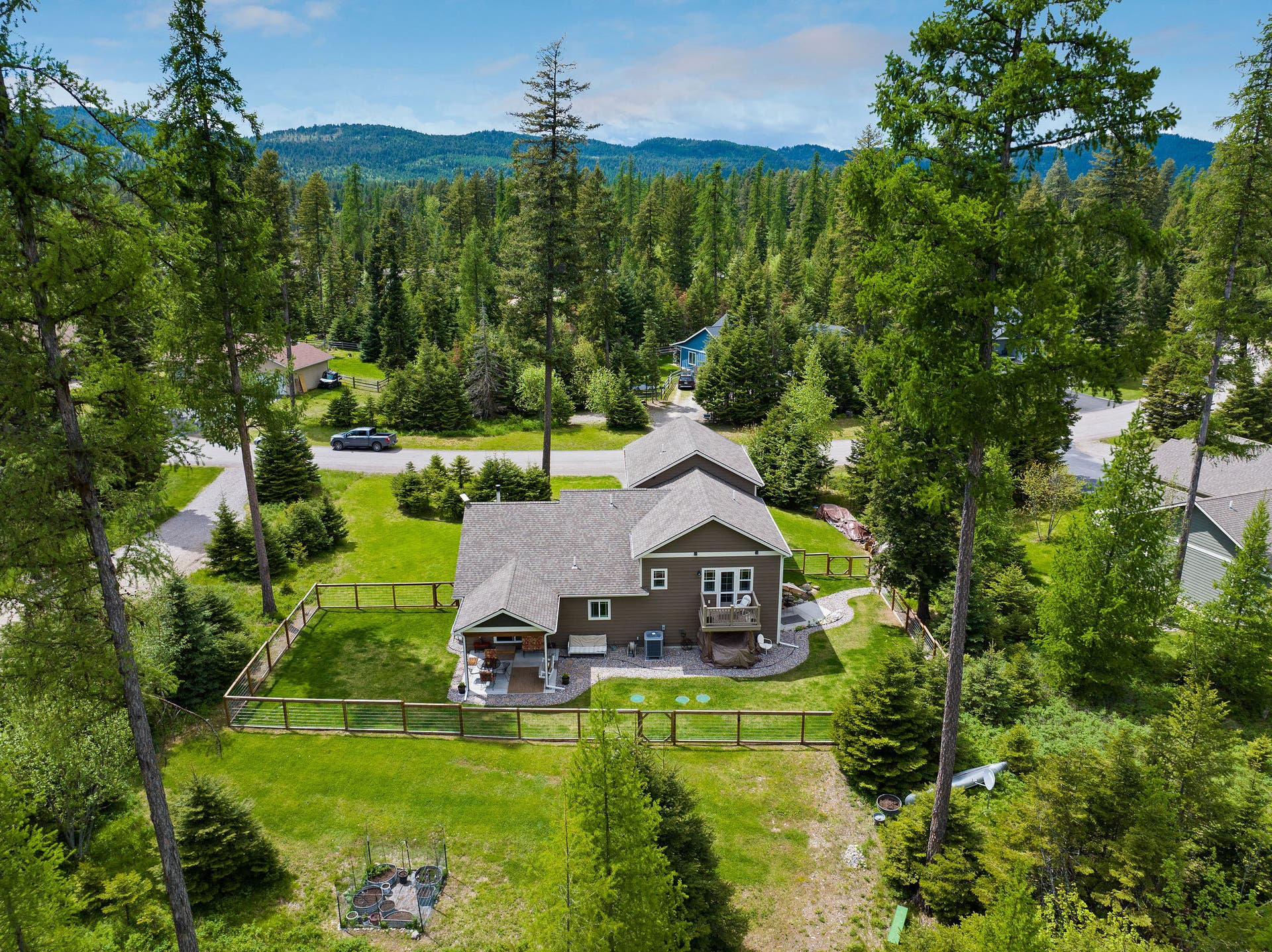 13404 Crescent Moon Drive, Bigfork, MT 59911 High-angle rear view highlighting the multi-level layout and expansive lawn