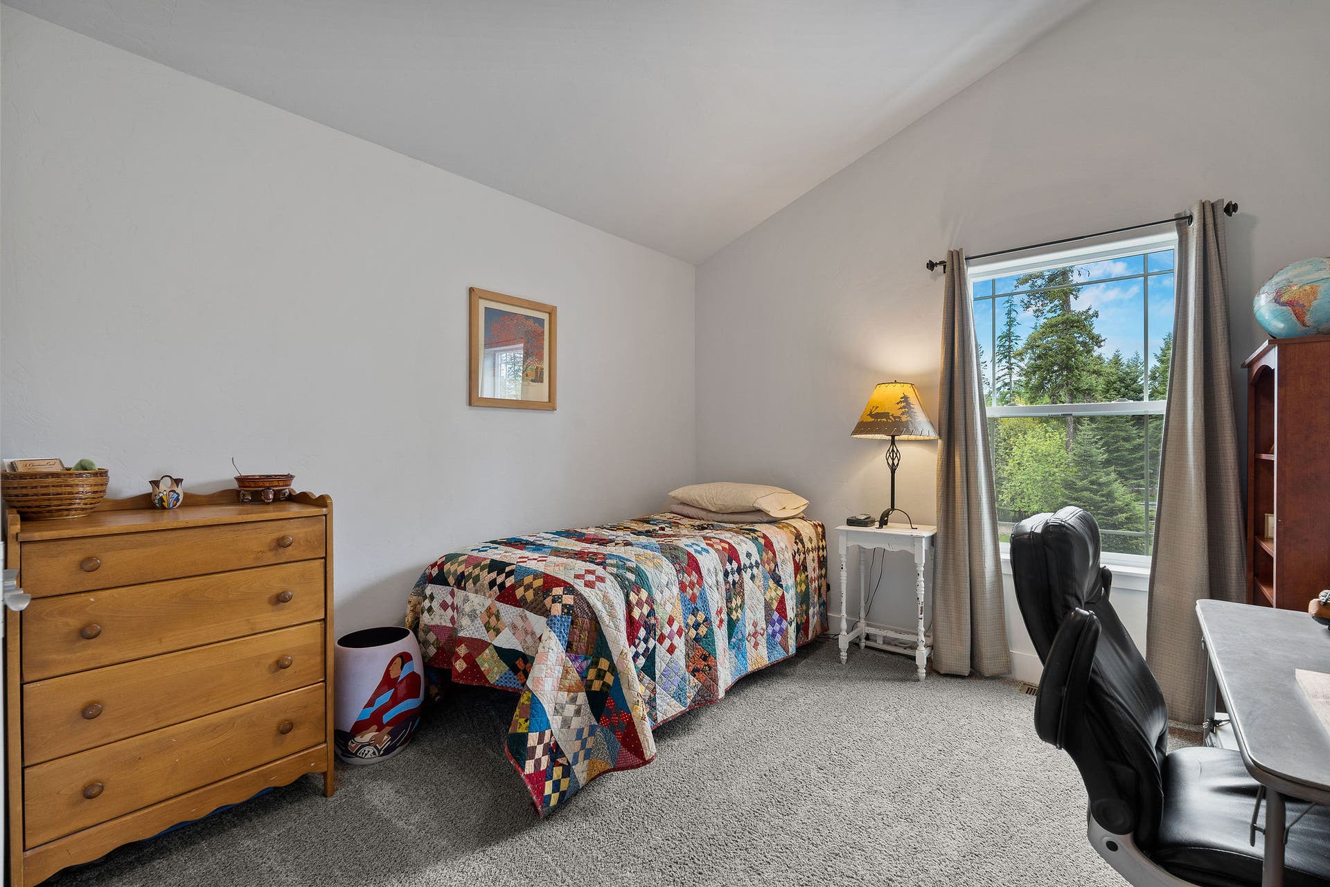 13404 Crescent Moon Drive, Bigfork, MT 59911 Cozy upper-level bedroom featuring a large window and vaulted ceiling