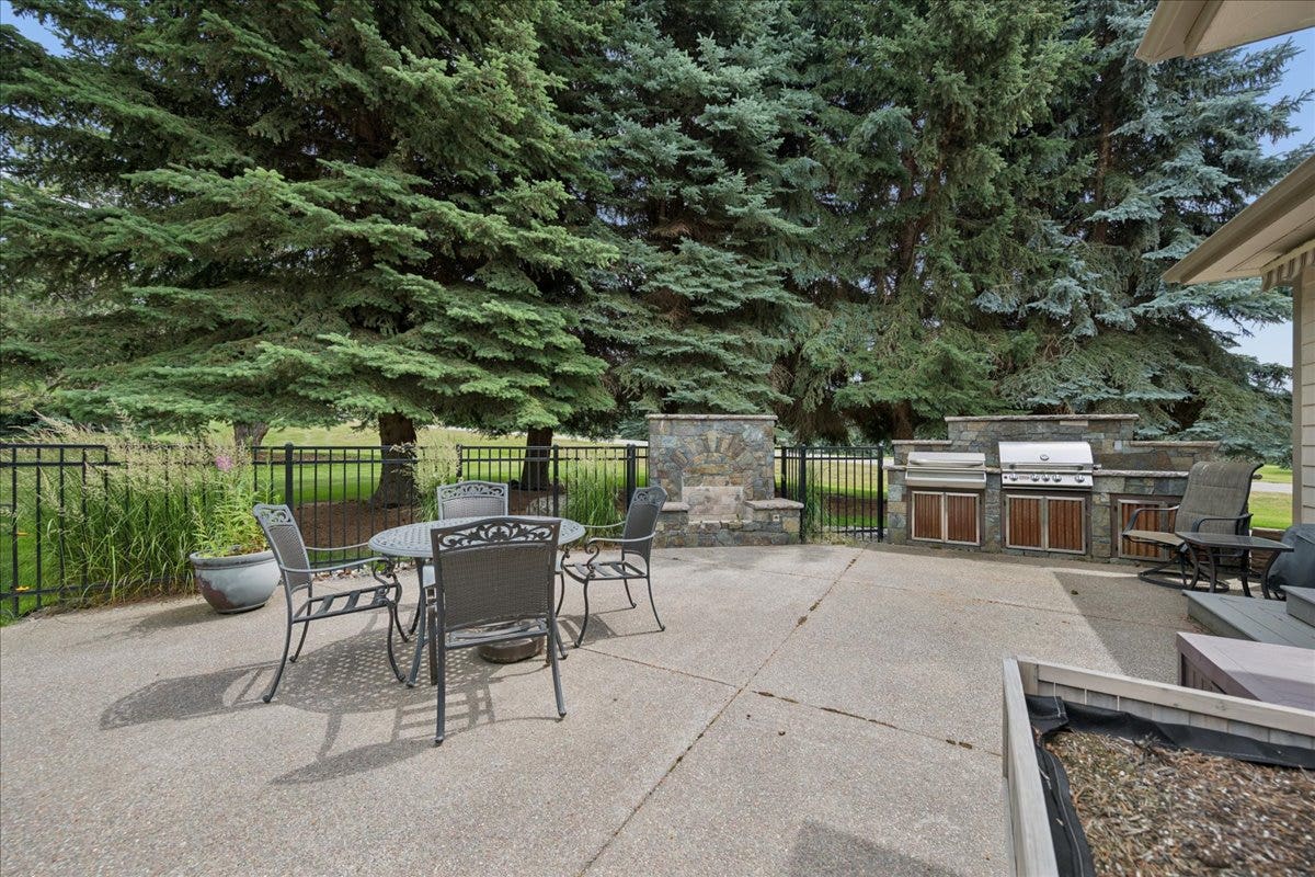 enjoy time on the patio surrounded by lush trees and grass