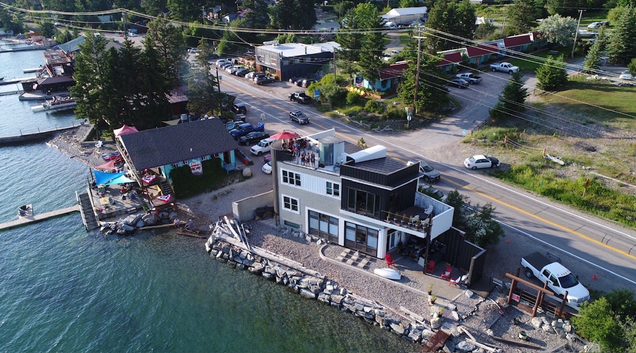 15335 MT Highway 35, Bigfork, MT 59911 Modern waterfront building with multiple outdoor patio spaces, a rooftop deck, and direct water access