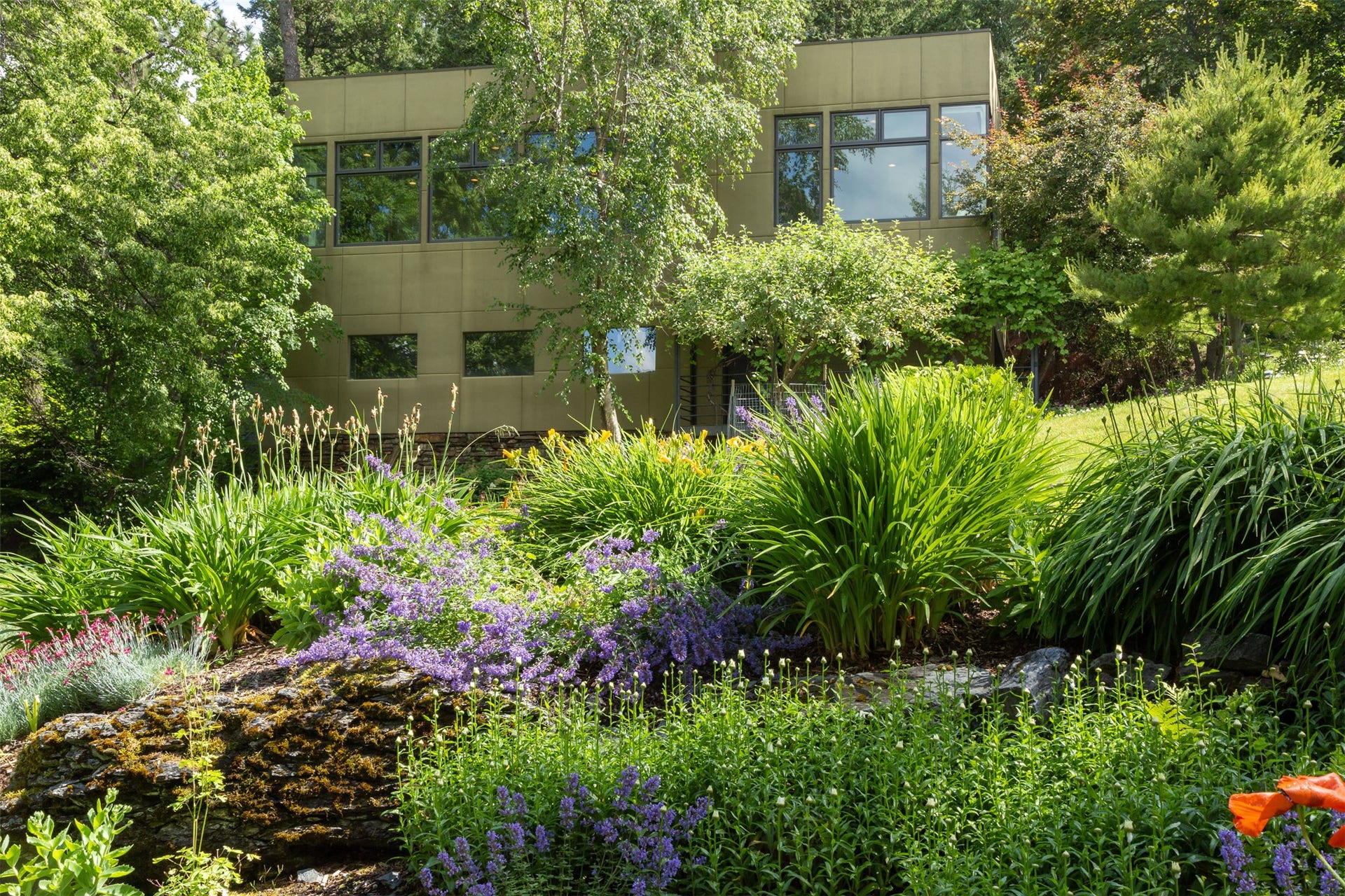 Lilies, are among the hundreds of perennials planted on terraces surrounding the home.