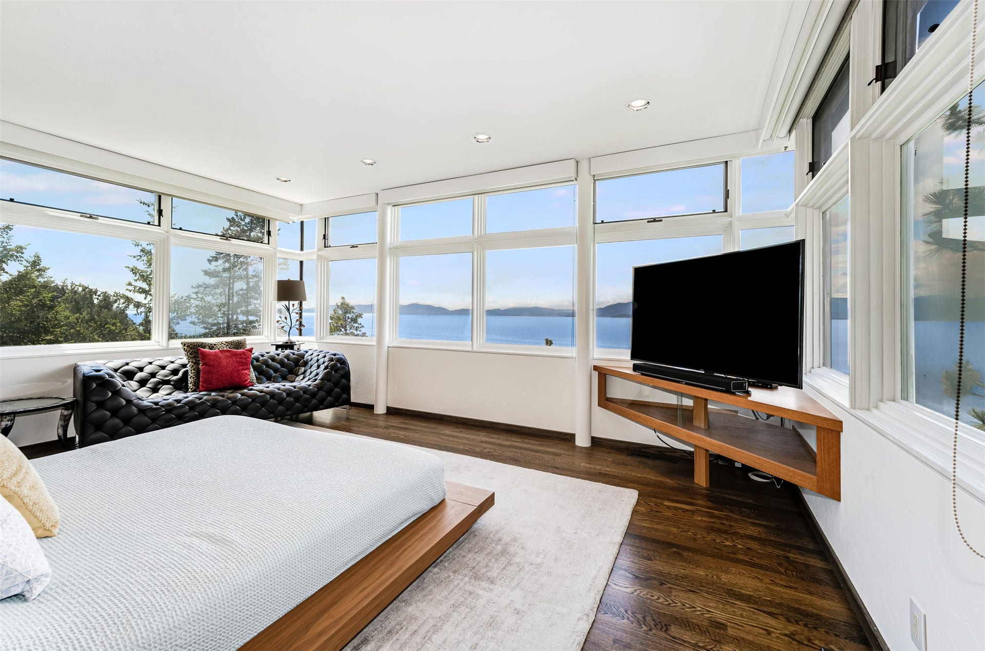Expansive window wall showcasing 40 miles of Flathead Lake shoreline over the tree tops.
