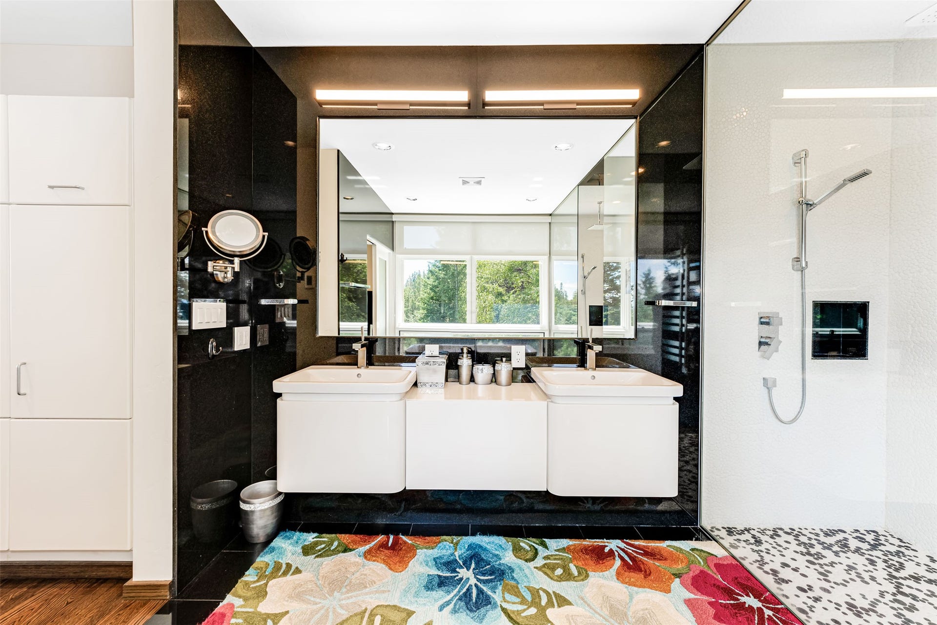 Dual vanity with white rectangular sinks, a wall-mounted mirror, and overhead strip lighting