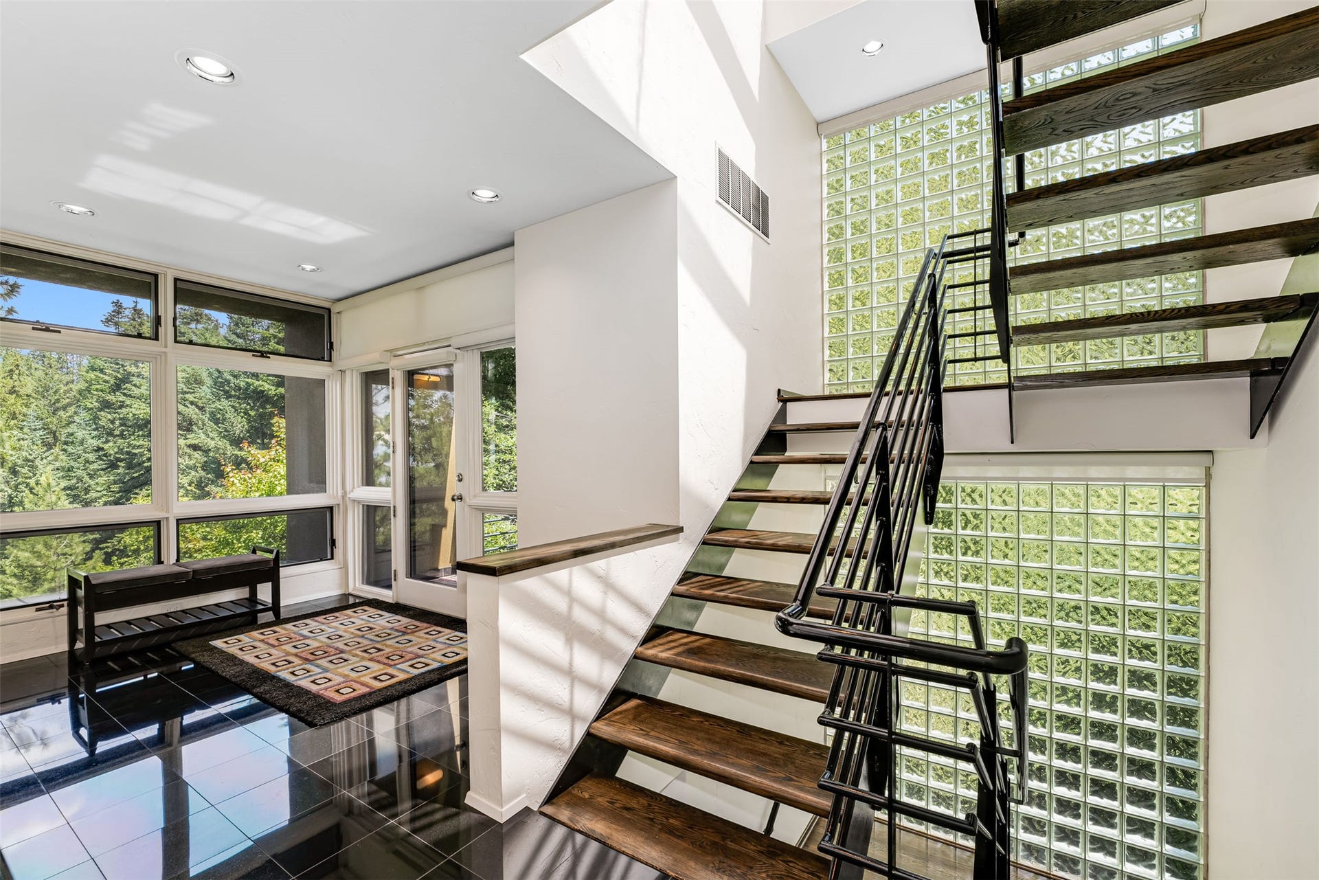 Open staircase featuring oak treads and a black forged iron railing.