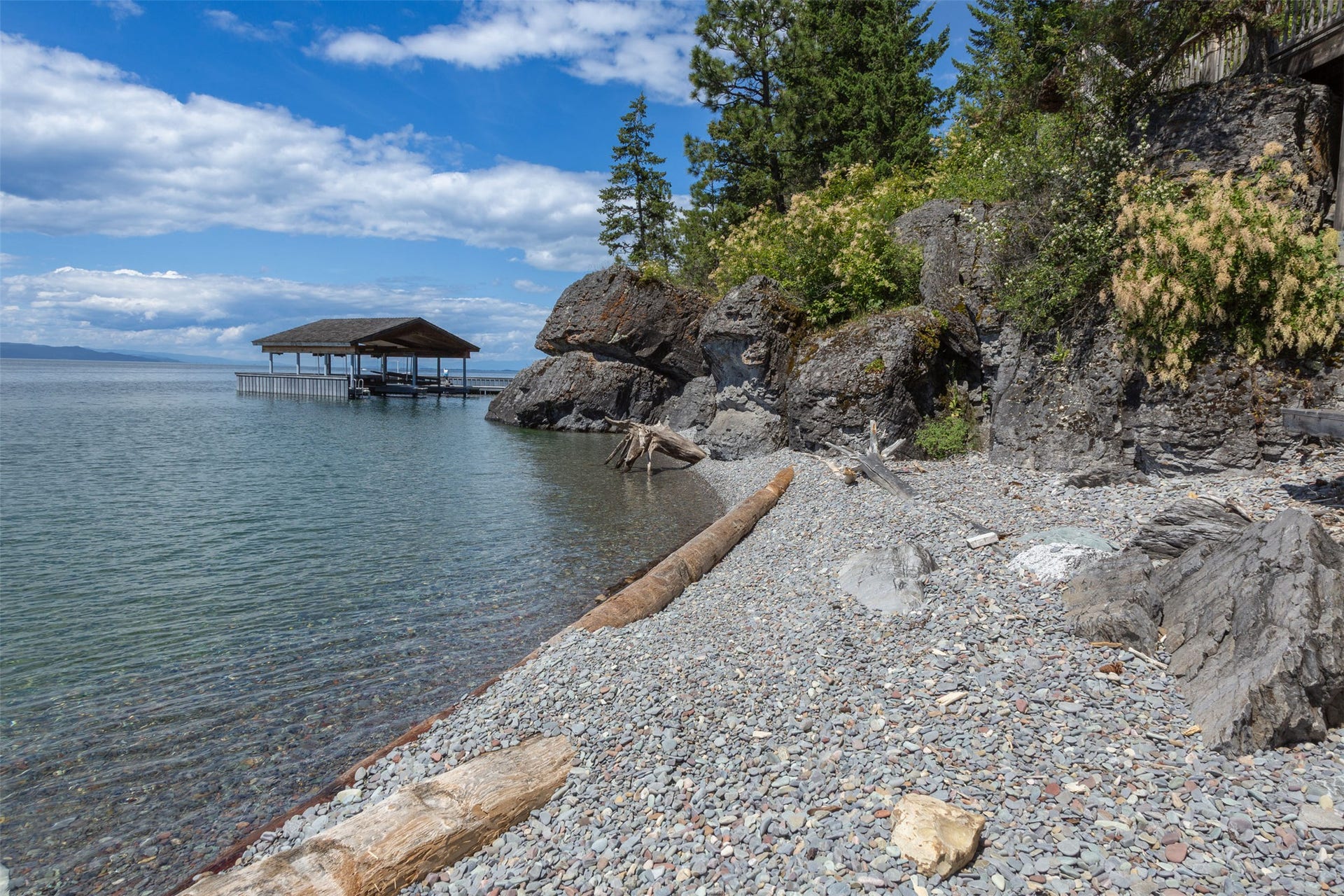 Waterfront property featuring your private covered docks, extensive pebble beach, and a natural rock and tree-lined paradise.
330 feet of rare Flathead Lake shore!