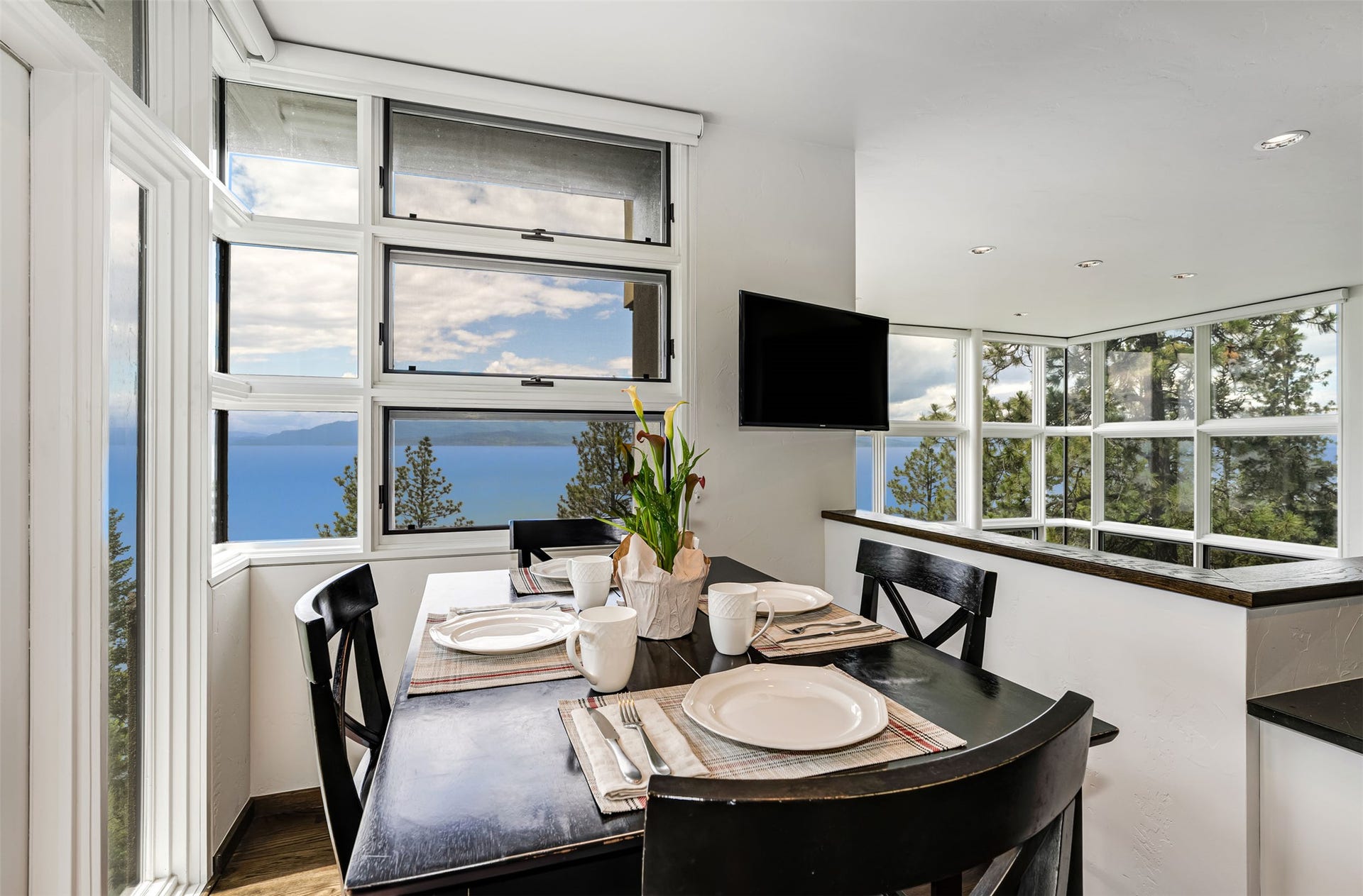 Enjoy morning coffee in this breakfast nook with expansive lake and tree scenery through multiple  windows. From here you can exit to the porch as well.