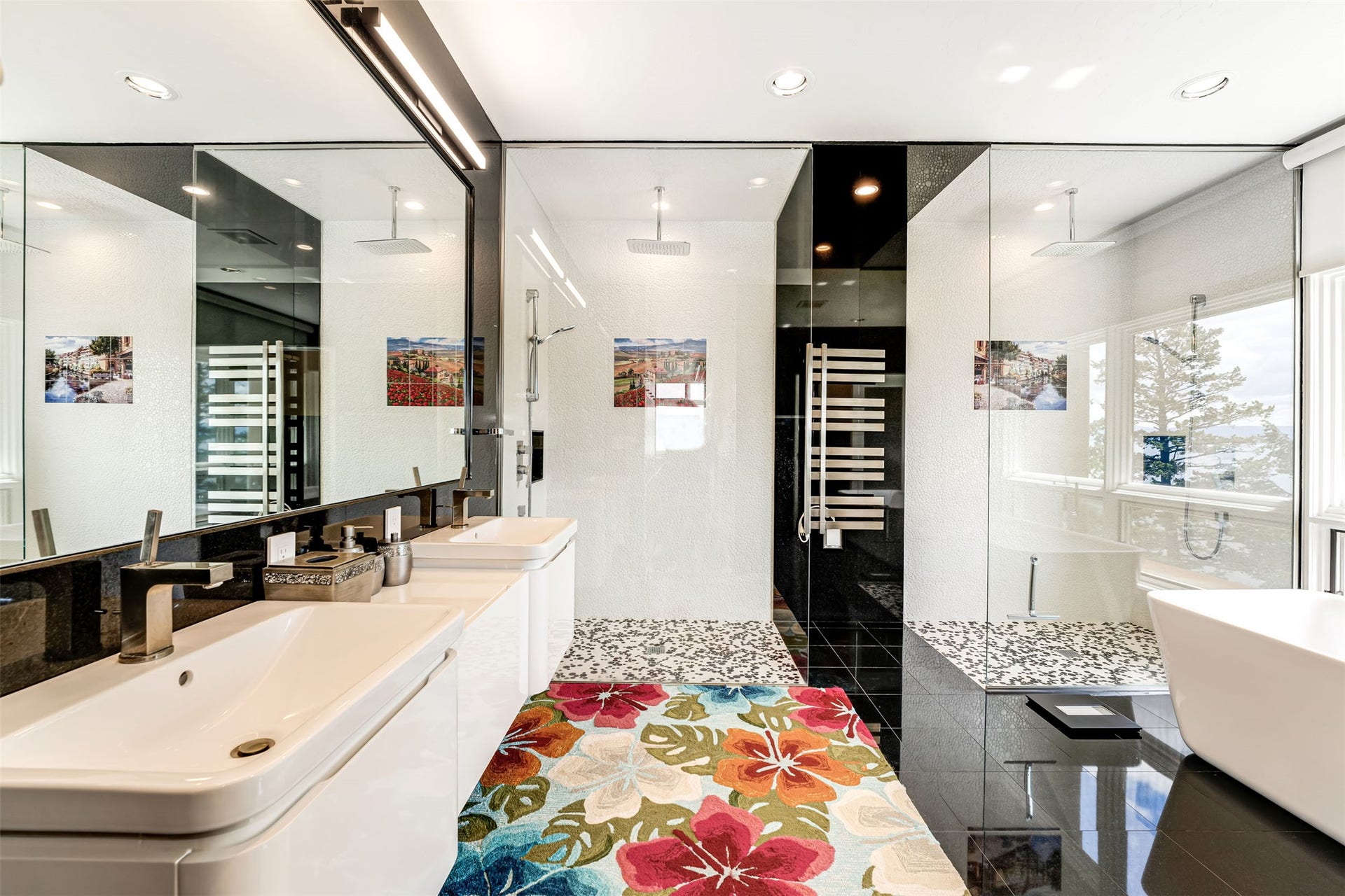 Modern bathroom featuring dual rectangular sinks, a sleek vanity with integrated storage, full-width mirrors, and a separate glass-enclosed shower with 2 rainfall showerheads.