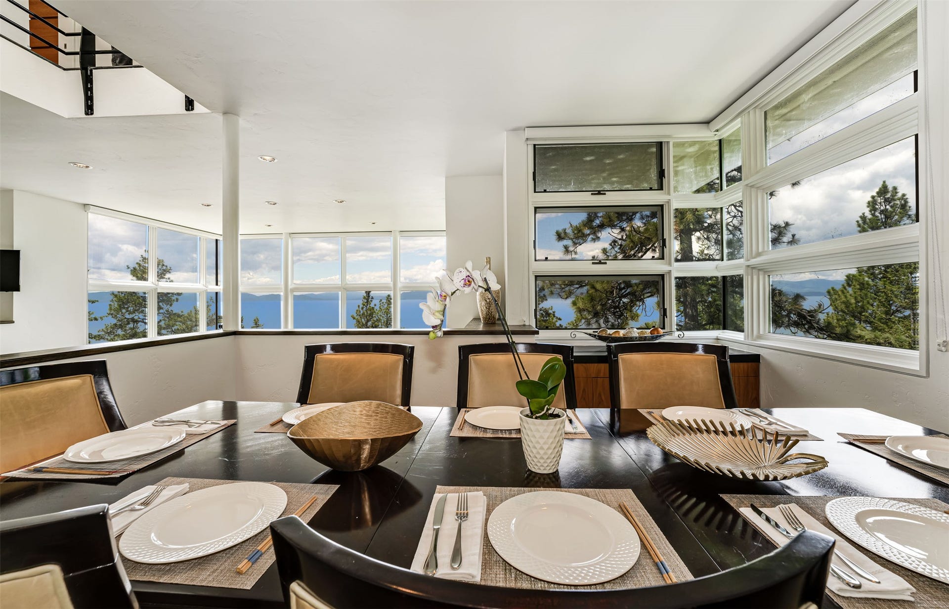 Dining area adjacent to kitchen and living room in this open floor plan design. Panoramic lake, tree and mountain views surround!