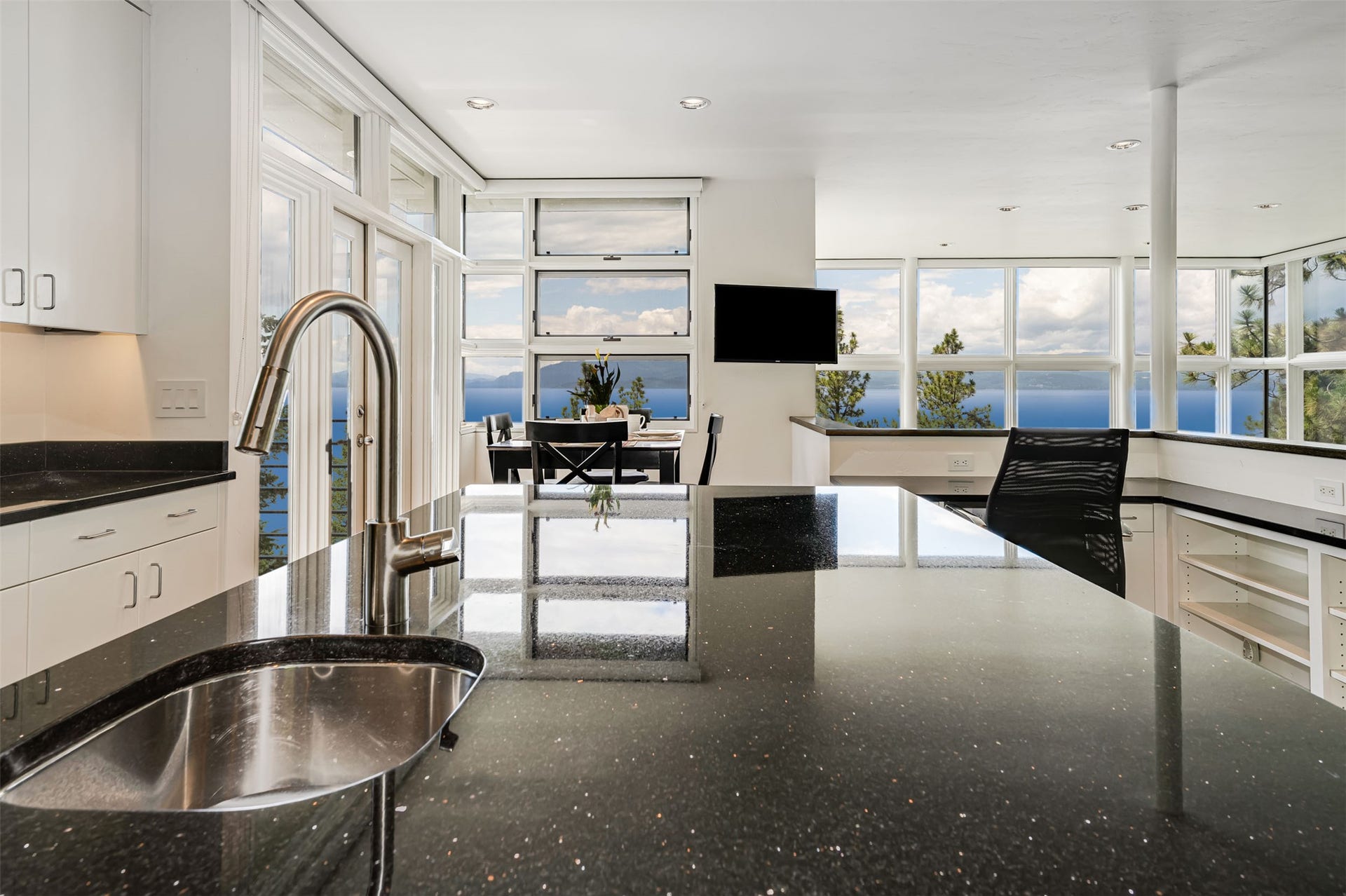 Modern kitchen island with a built-in stainless steel sink and a contemporary gooseneck faucet