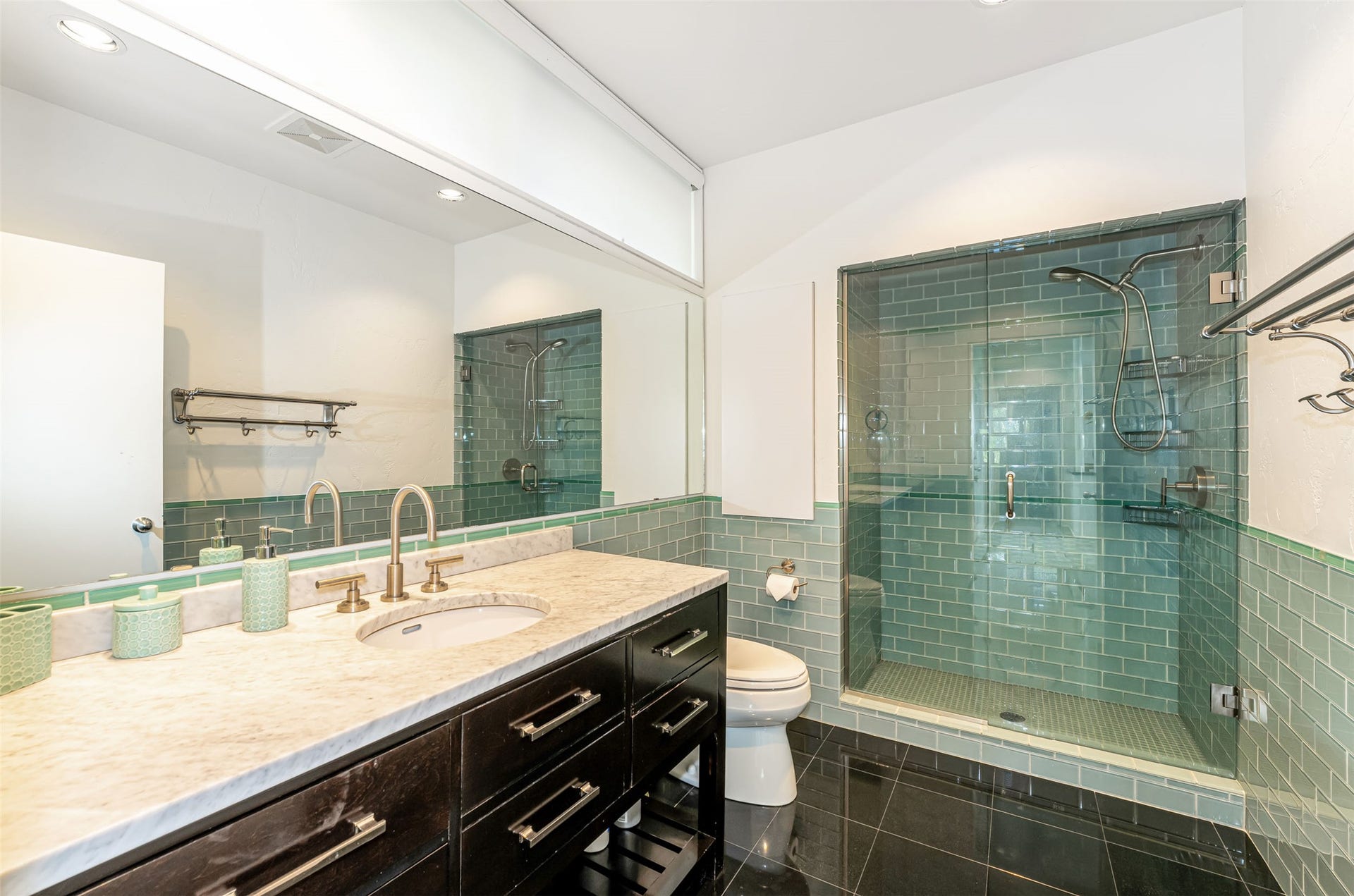 Bathroom featuring a dark wood-finish vanity with a light-toned countertop, an undermount sink, and a gold-tone faucet