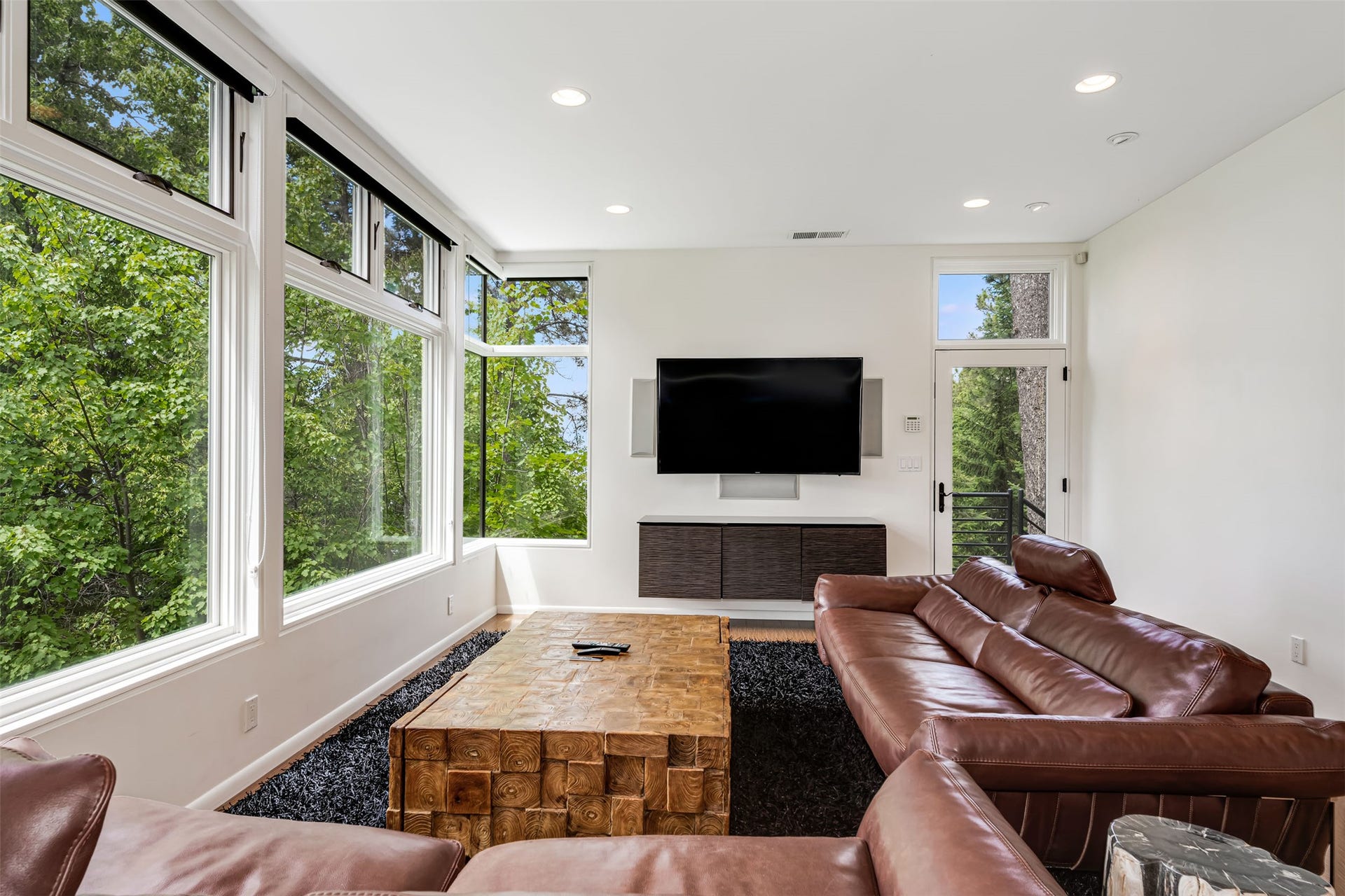 A studio apartment with 2 bedrooms and 2 bathrooms is above the garage. Expansive window wall provides lake view through the trees past the main house below.