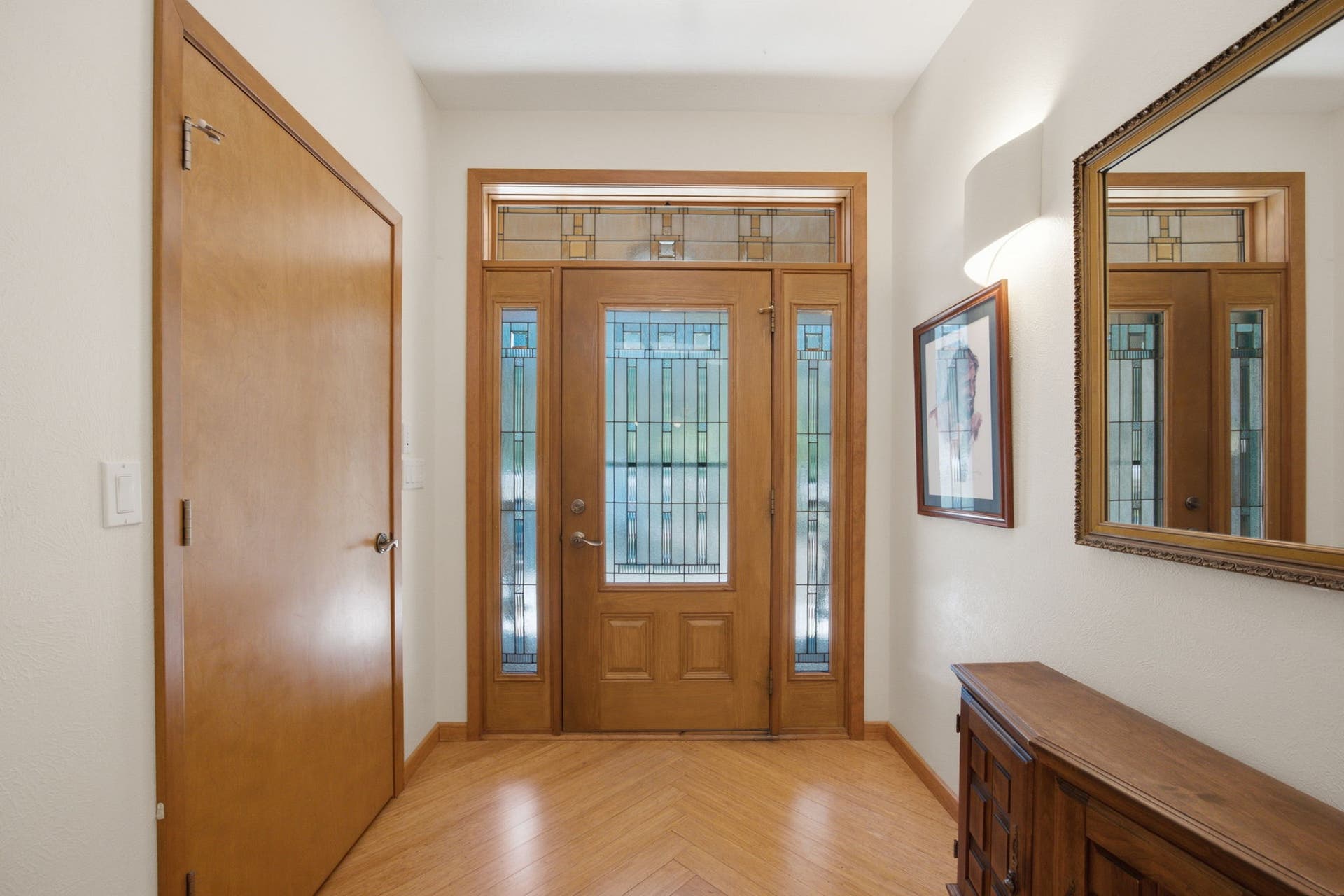 Step inside to a bright and welcoming foyer featuring a beautiful front entry door with decorative glass, warm wood finishes, and an inviting first impression that sets the tone for the home's thoughtful design.