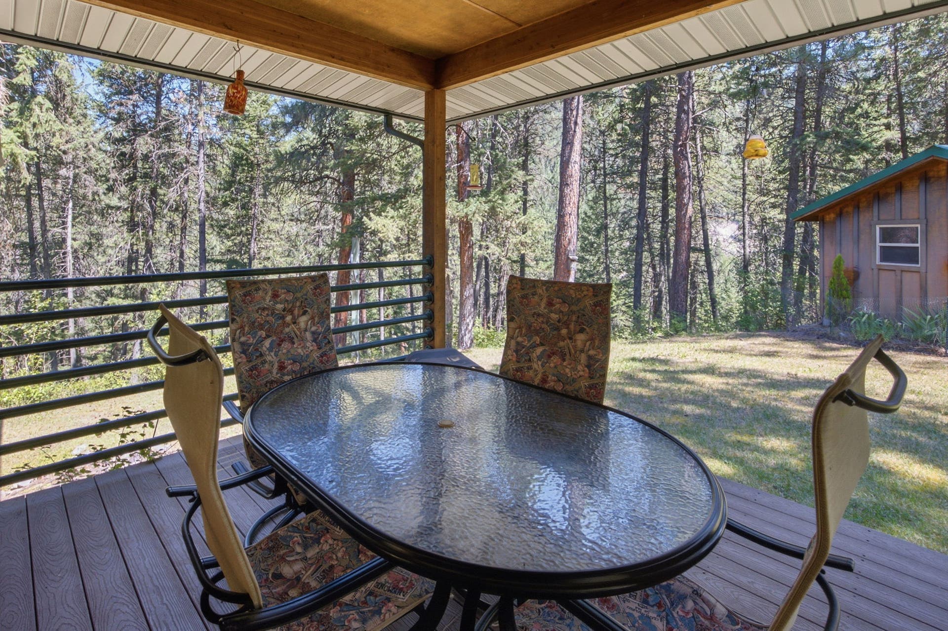 Multiple seating areas invite you to unwind while enjoying the peaceful wooded surroundings, creating a seamless connection between the comfort of the home and the beauty of the landscape.
