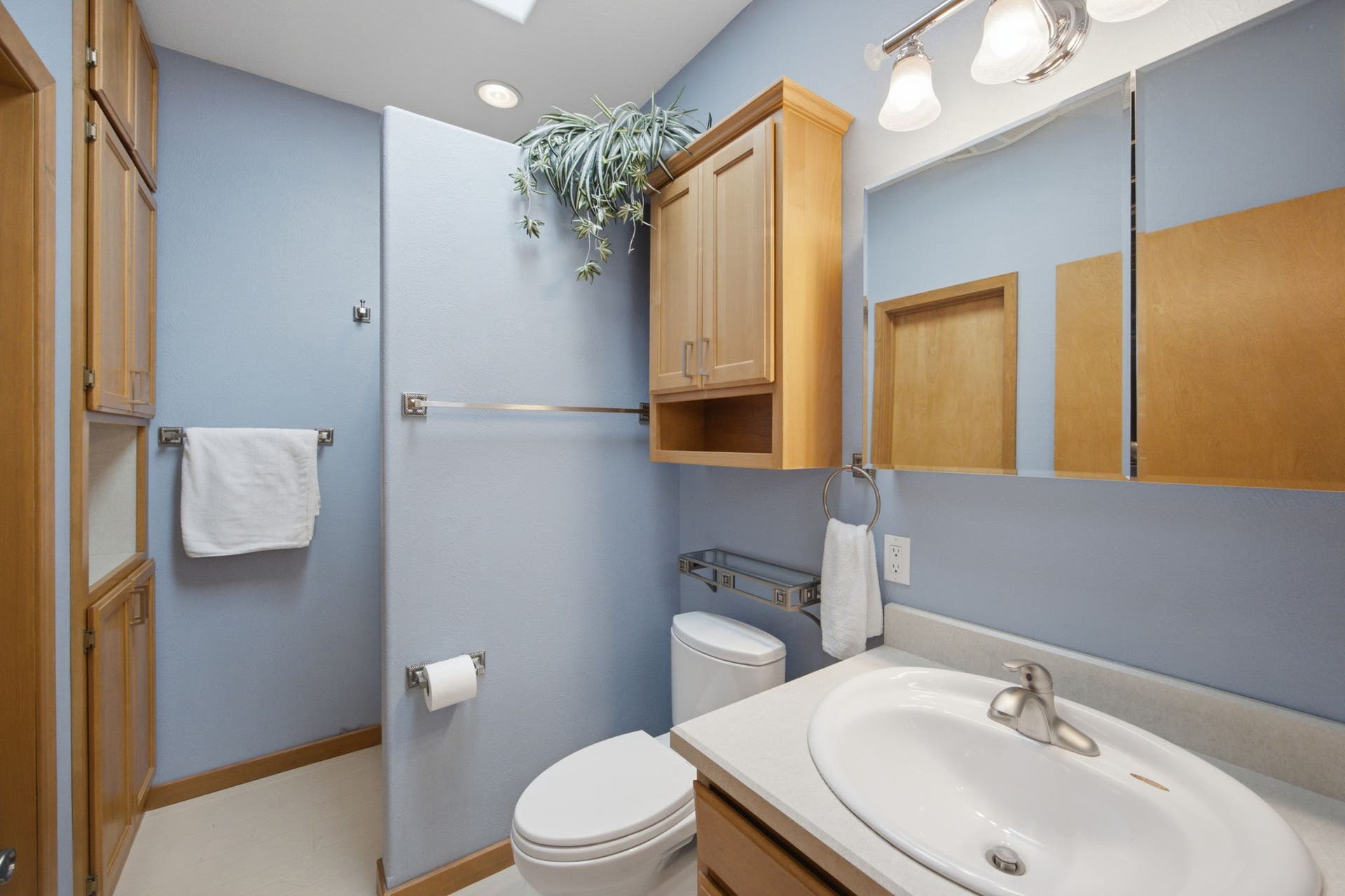 A bright and inviting guest bathroom features a spacious vanity, convenient storage, and a practical layout designed to comfortably serve family and visitors.