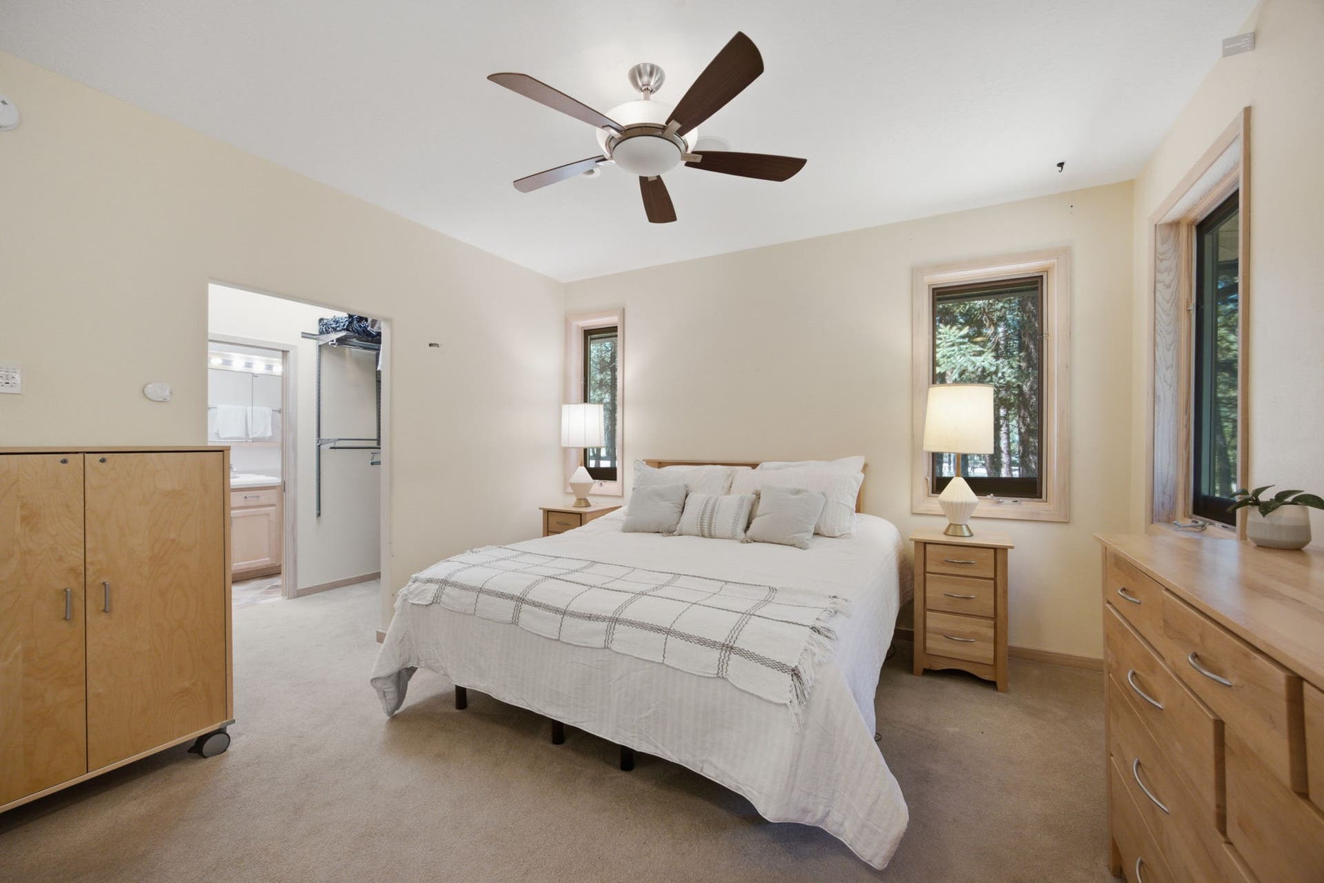 Thoughtfully positioned for privacy, the primary bedroom features serene views of the surrounding pines, creating a quiet escape at the end of the day.