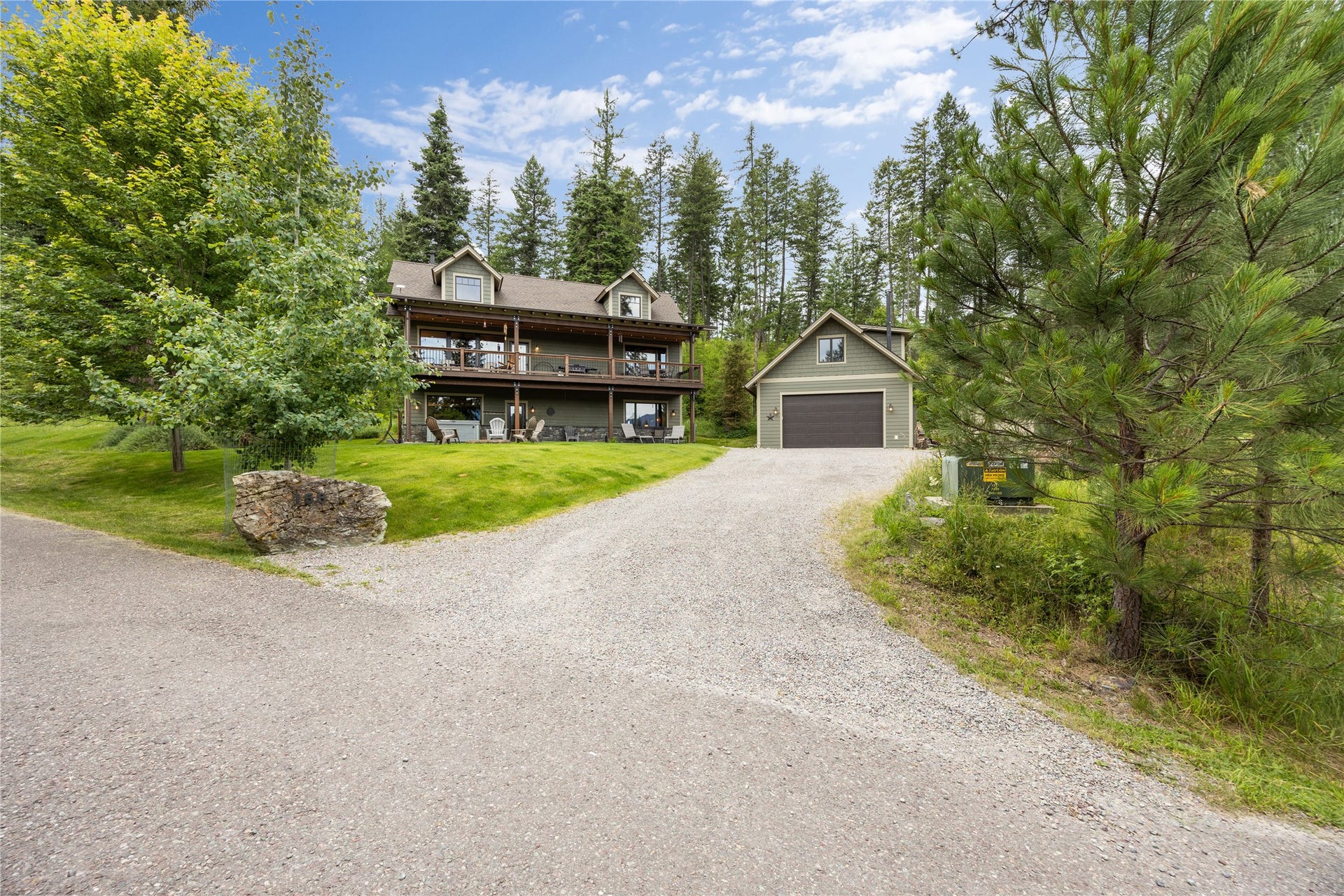 158 McCaffery Lookout Trail, Bigfork, MT 59911 Two-story residence featuring dormer windows, balconies on both levels, and a detached two-car garage