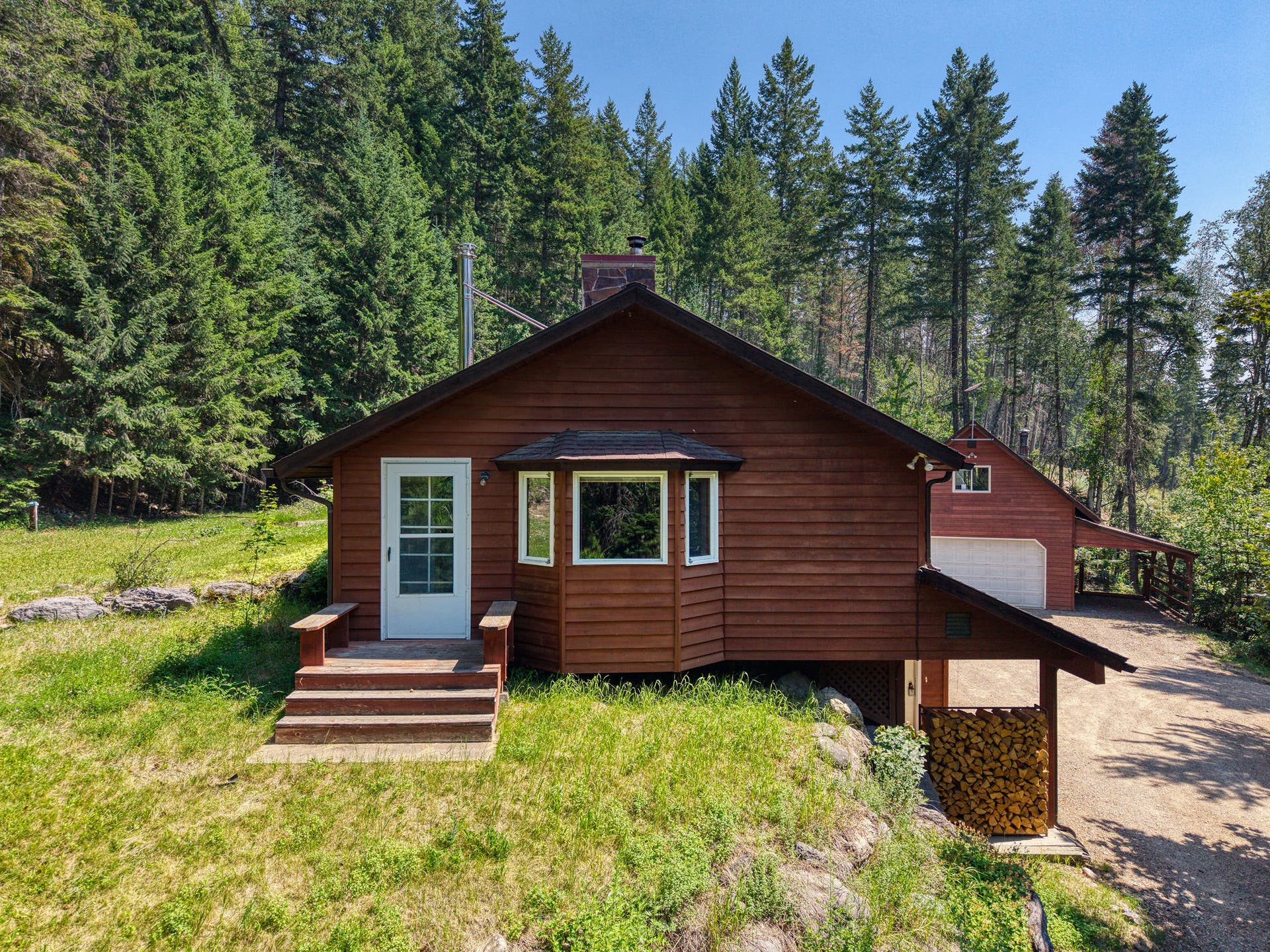 244 Bench Drive, Kalispell, MT 59901 Exterior view of 1980s wood-sided home on 3 acres with no HOA in Kalispell Montana.