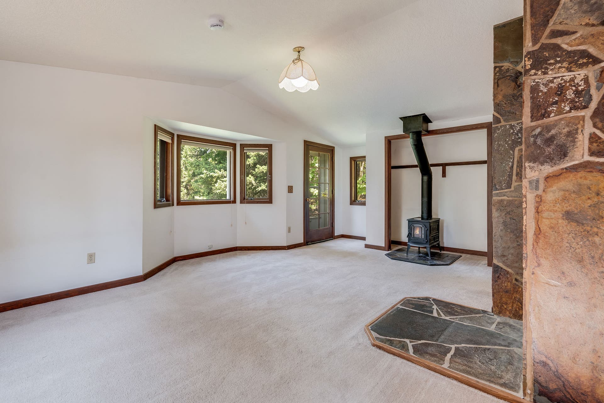 244 Bench Drive, Kalispell, MT 59901 Spacious primary bedroom with wood accents and natural lighting in Kalispell real estate listing. Generous primary bedroom with updated stove and plenty of natural light.