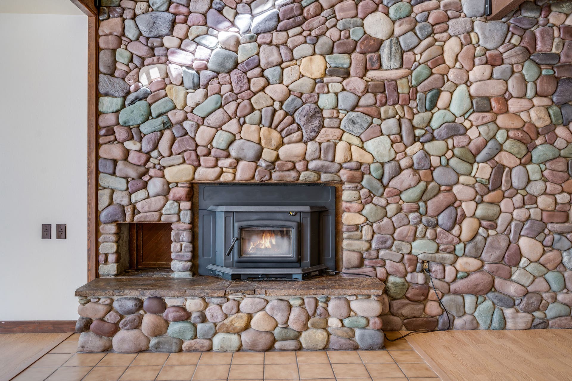 244 Bench Drive, Kalispell, MT 59901 Spacious living room featuring a rock surround wood burning stove in a Kalispell Montana home. Spacious main living area centered around a stunning rock-surround wood-burning stove for cozy Montana evenings.
