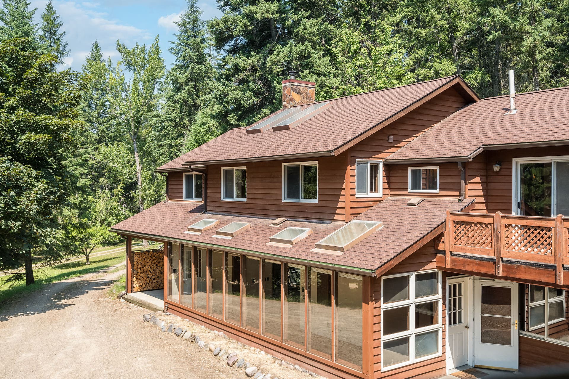 244 Bench Drive, Kalispell, MT 59901 Exterior view of 1980s wood-sided home on 3 acres with no HOA in Kalispell Montana.