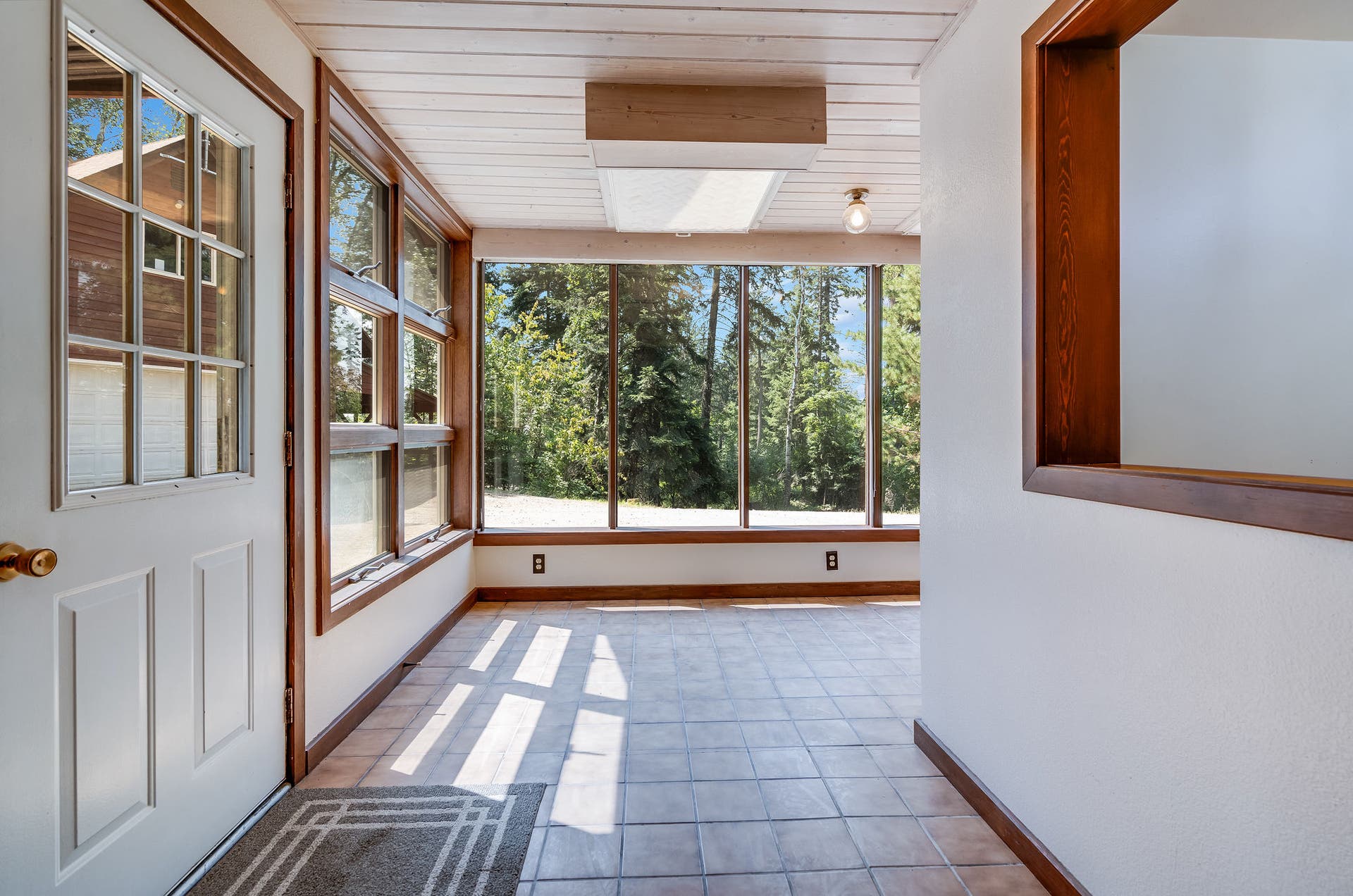 244 Bench Drive, Kalispell, MT 59901 Kalispell MT home with sunroom entry, floor-to-ceiling windows, and natural light. Sun-drenched sunroom entry wrapped in full windowsthe ultimate light-filled mudroom or morning coffee nook.