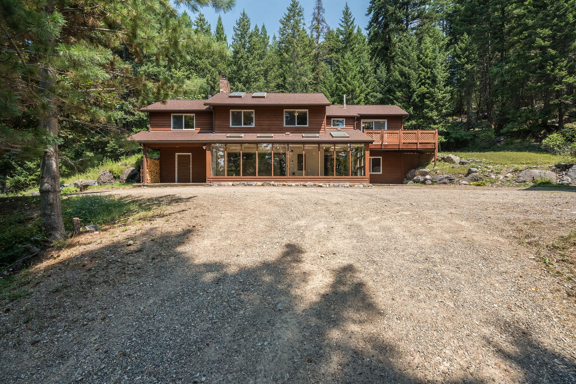 244 Bench Drive, Kalispell, MT 59901 Exterior view of 1980s wood-sided home on 3 acres with no HOA in Kalispell Montana.
