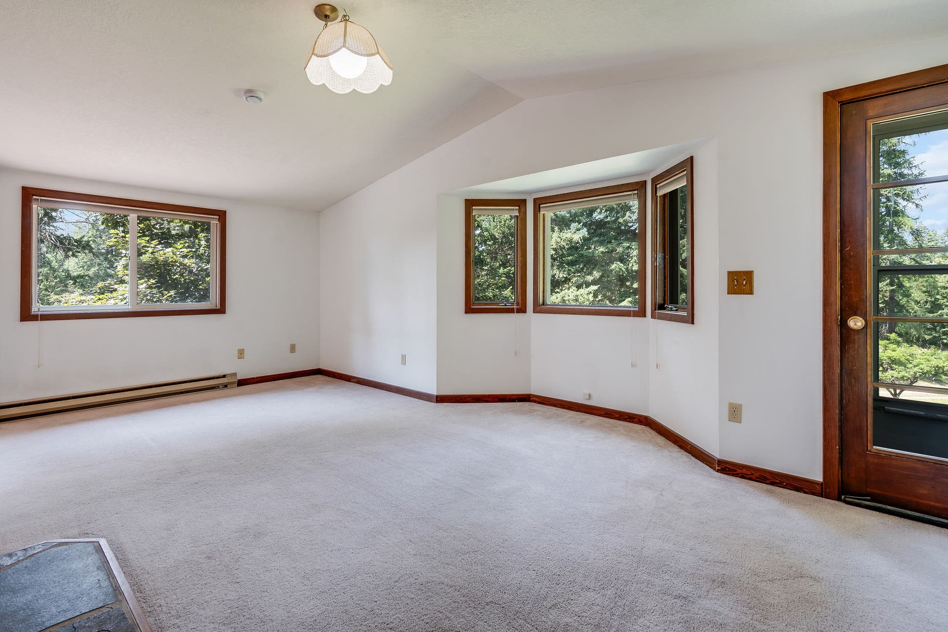 244 Bench Drive, Kalispell, MT 59901 Spacious primary bedroom with wood accents and natural lighting in Kalispell real estate listing. Generous primary bedroom with updated stove and plenty of natural light.