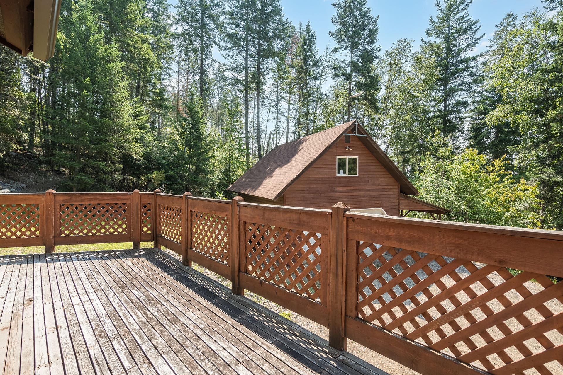 244 Bench Drive, Kalispell, MT 59901 Exterior view of 1980s wood-sided home with deck on 3 acres with no HOA in Kalispell Montana.