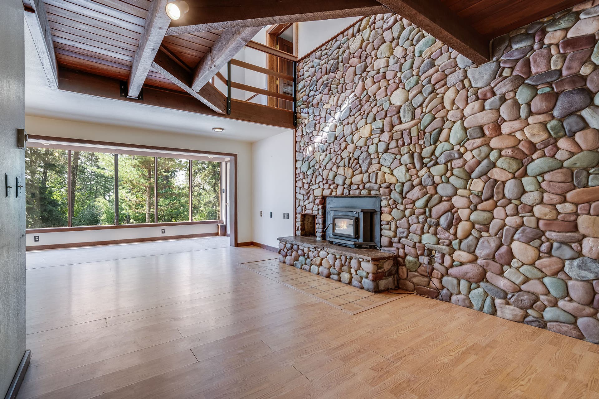 244 Bench Drive, Kalispell, MT 59901 Spacious living room featuring a rock surround wood burning stove in a Kalispell Montana home. Spacious main living area centered around a stunning rock-surround wood-burning stove for cozy Montana evenings.