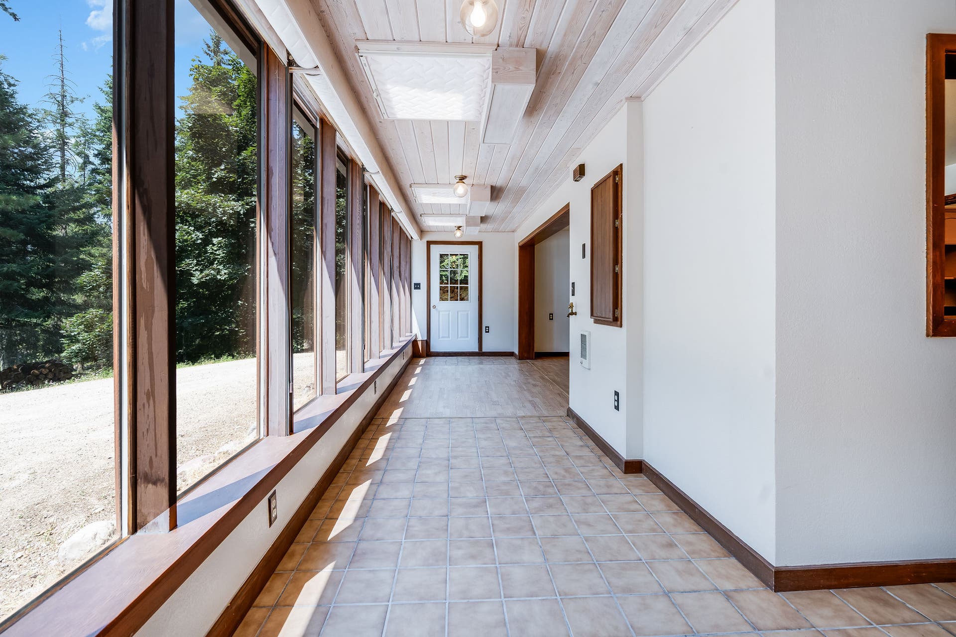 244 Bench Drive, Kalispell, MT 59901 Kalispell MT home with sunroom entry, floor-to-ceiling windows, and natural light. Sun-drenched sunroom entry wrapped in full windowsthe ultimate light-filled mudroom or morning coffee nook.
