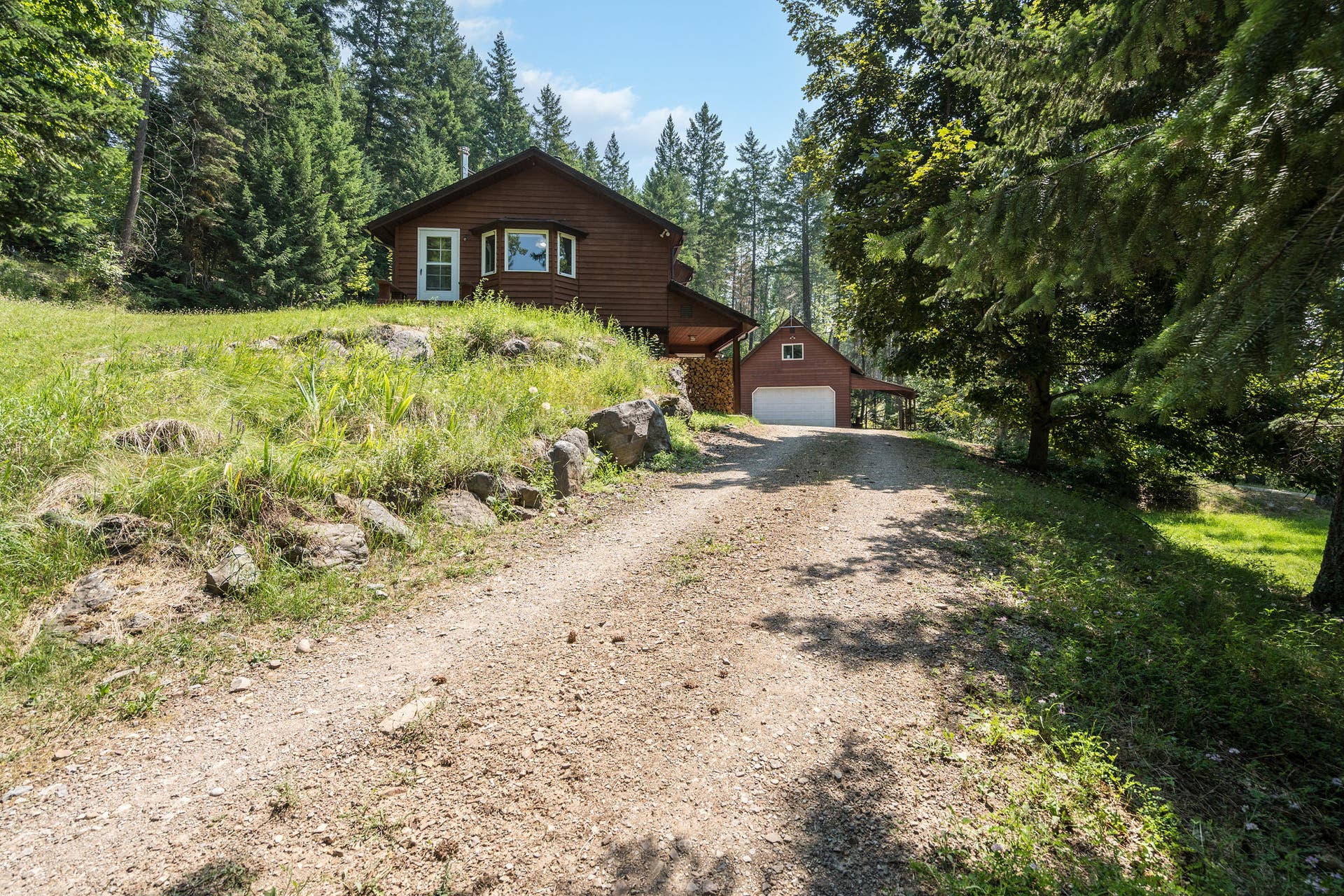 244 Bench Drive, Kalispell, MT 59901 Exterior view of 1980s wood-sided home on 3 acres with no HOA in Kalispell Montana.