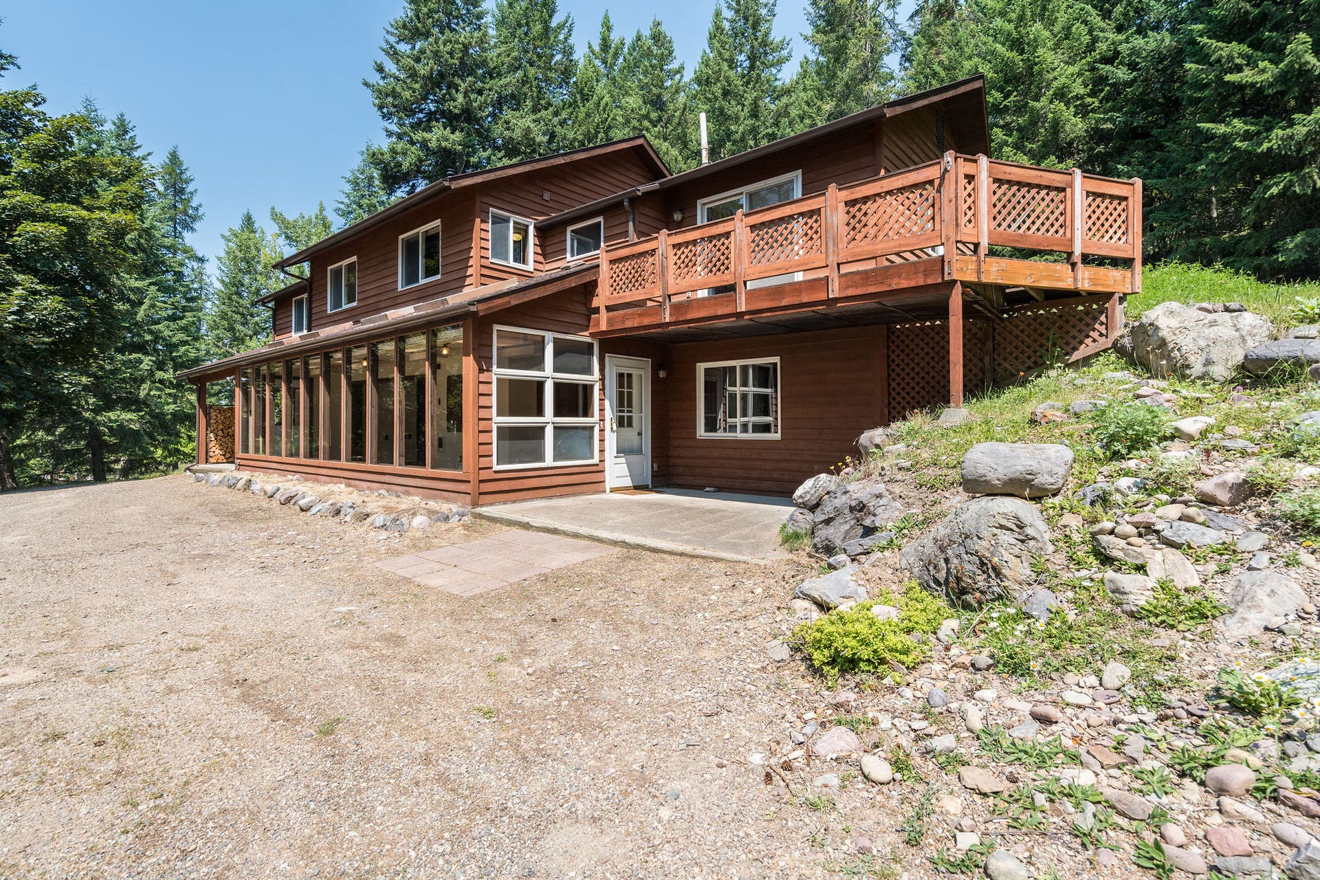 244 Bench Drive, Kalispell, MT 59901 Exterior view of 1980s wood-sided home on 3 acres with no HOA in Kalispell Montana.