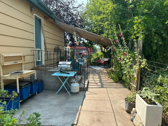 Side patio area featuring a concrete surface, a partial awning, and an exterior door