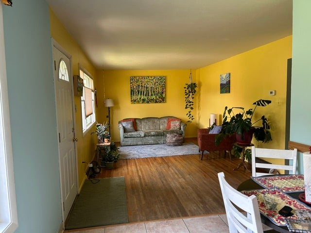 Spacious living area with hardwood floors and sunny picture window.