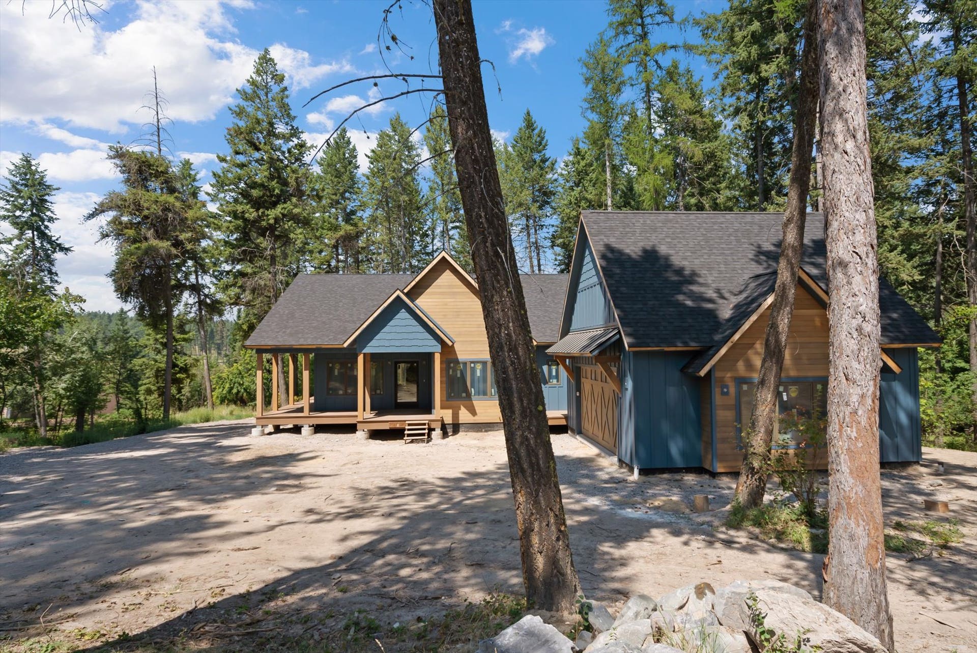 33542 Westview Drive, Bigfork, MT 59911 Front exterior framed by mature trees, highlighting the spacious front entry area