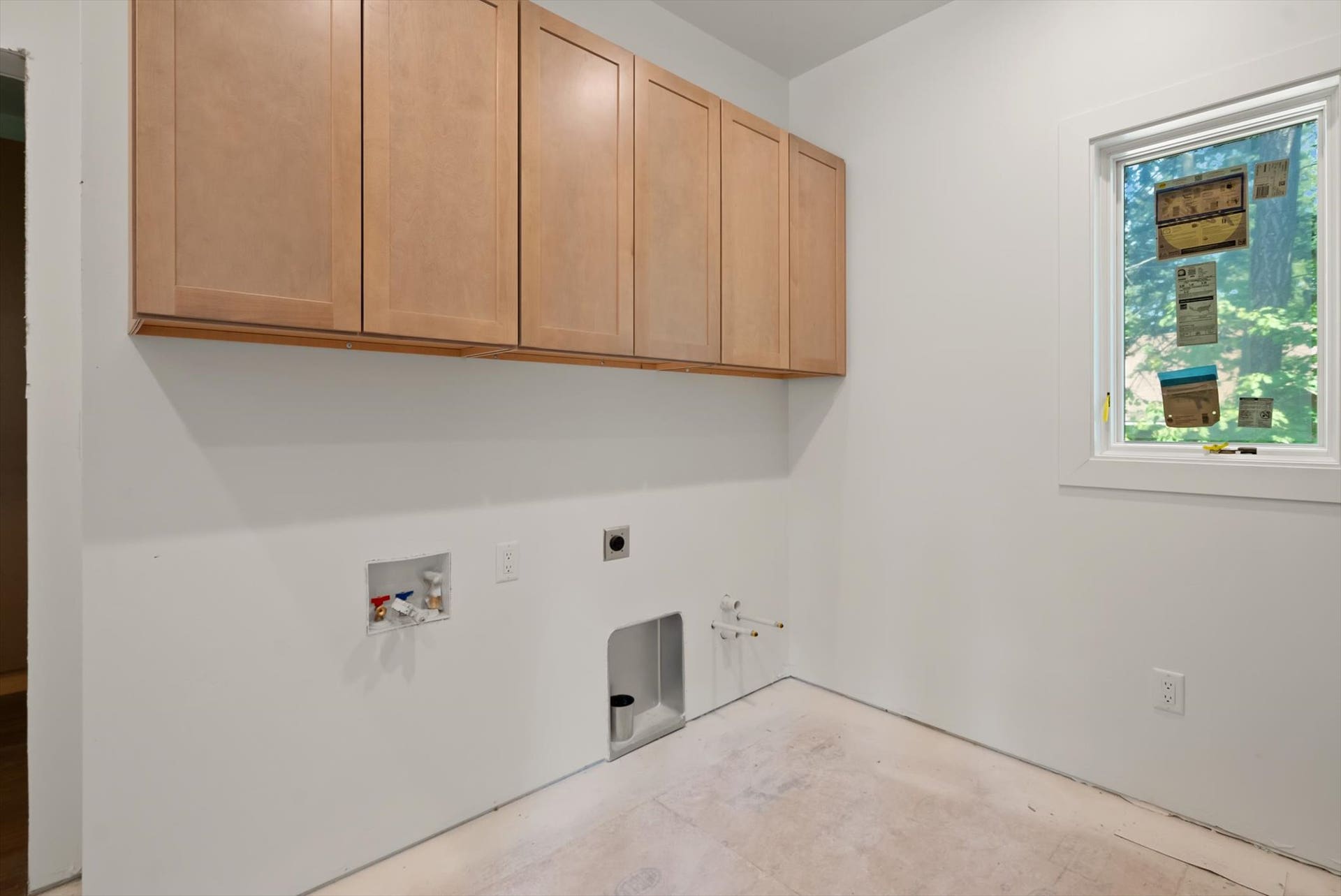 33542 Westview Drive, Bigfork, MT 59911 Dedicated main-level laundry room featuring upper storage cabinets and utility hookups