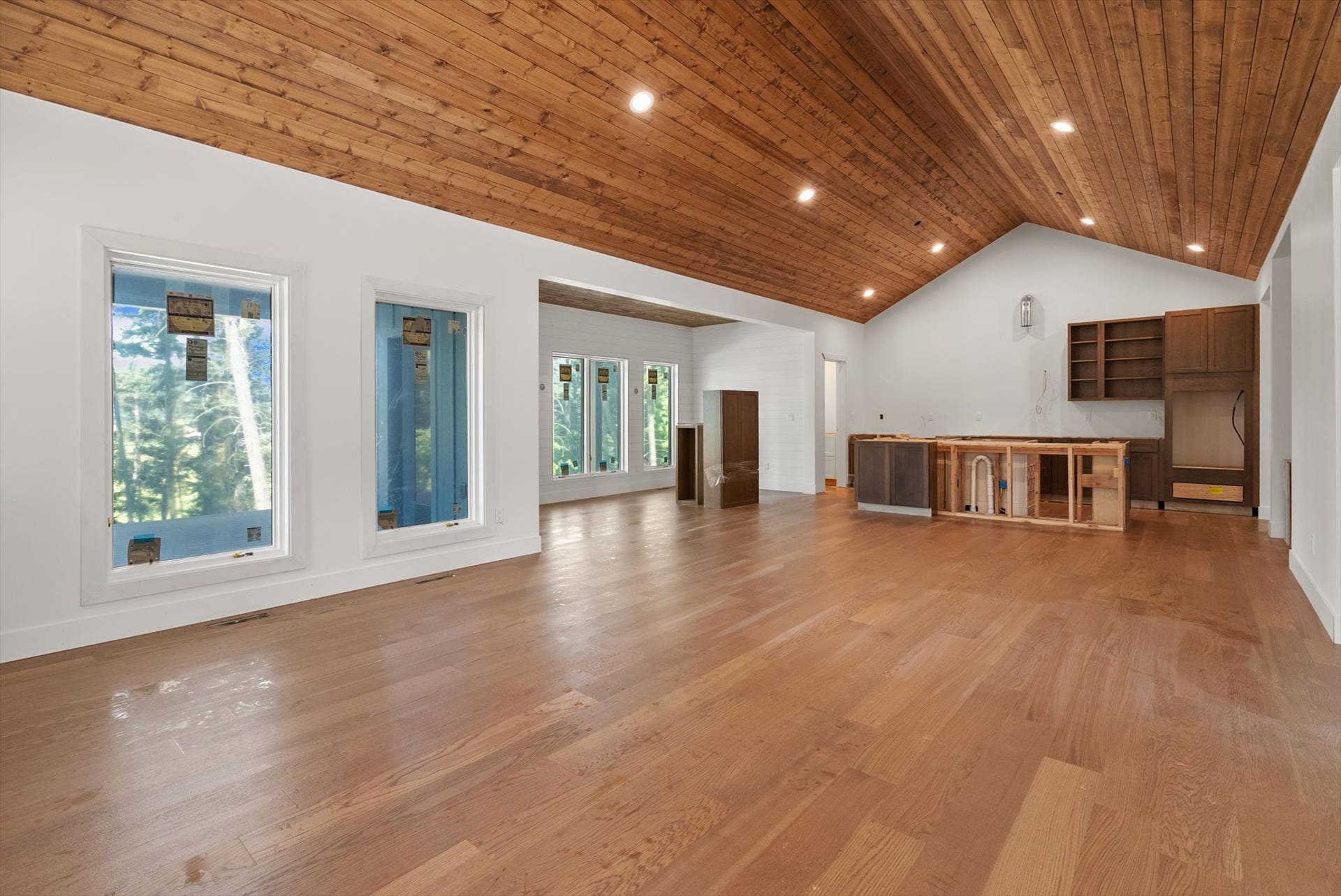 33542 Westview Drive, Bigfork, MT 59911 Open-concept great room with vaulted wood ceilings, LVP flooring, and kitchen & dining area