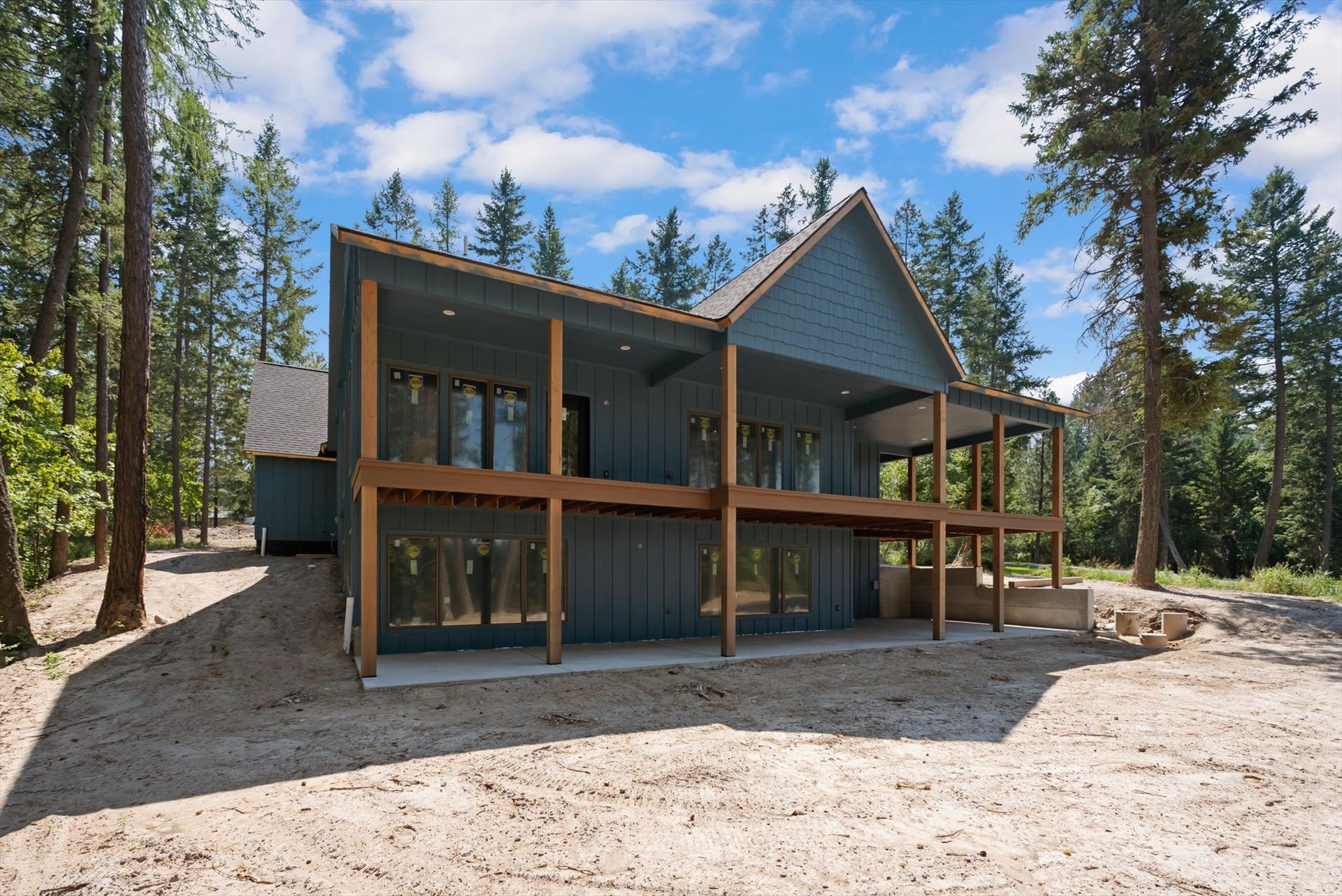 33542 Westview Drive, Bigfork, MT 59911 Exterior side angle showing the upper covered deck and lower walkout patio area