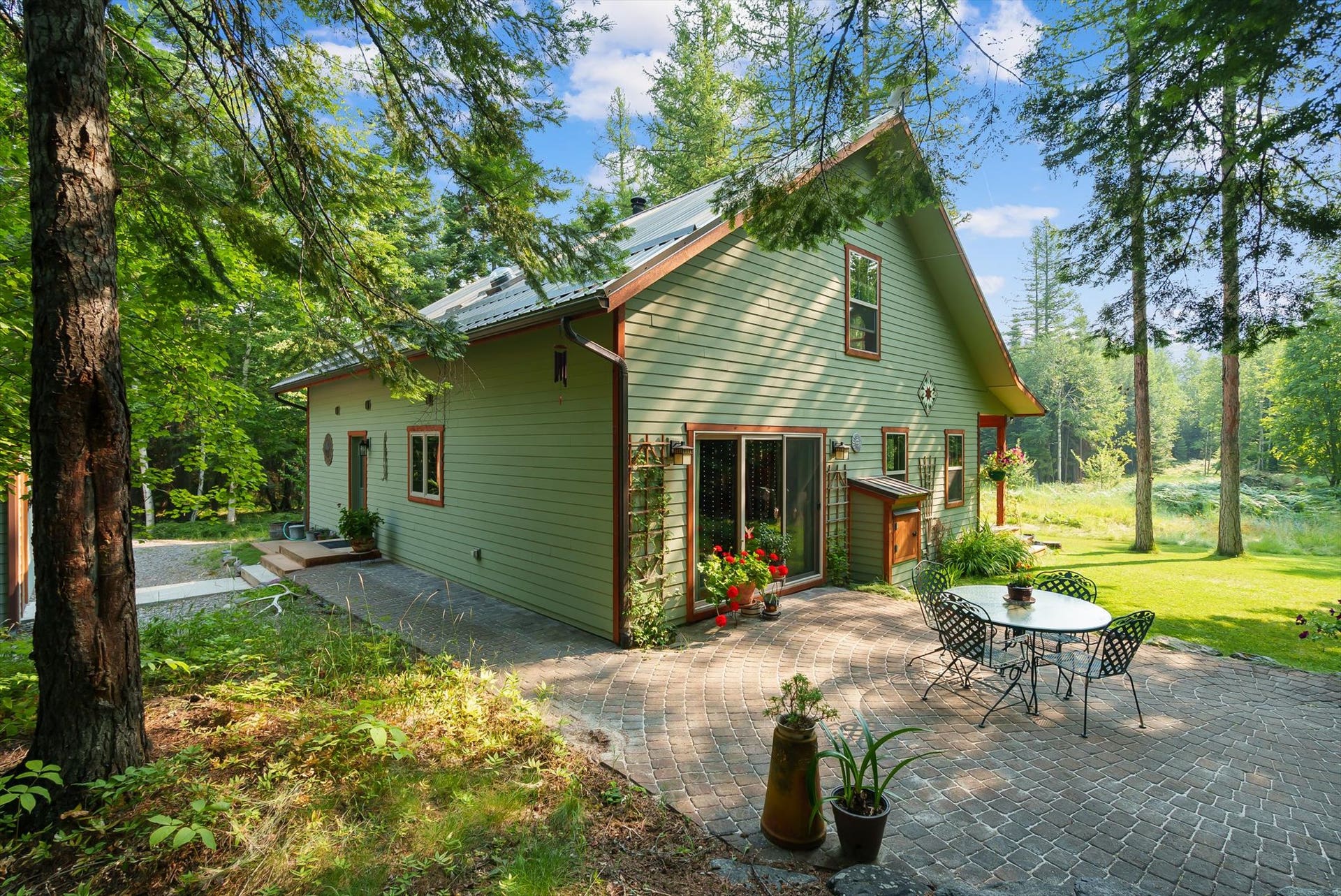 13786 Ridge Loop Road, Bigfork, MT 59911 Side brick patio, pass through firewood storage, and walkway to the detached garage