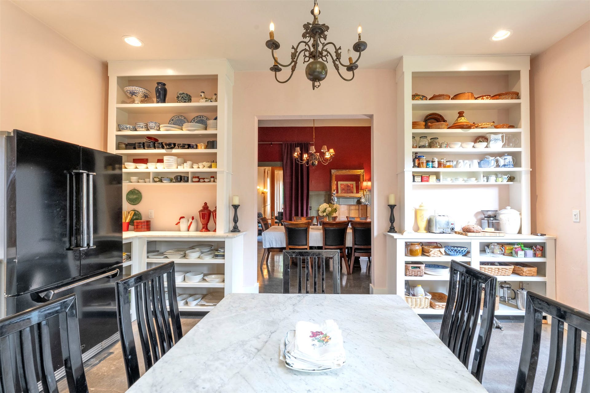 21848 Mt Highway 35, Bigfork, MT 59911 Breakfast area of kitchen featuring a chandelier, built-in shelving, and a black enamel Aga refrigerator. Looking toward the dining room door.