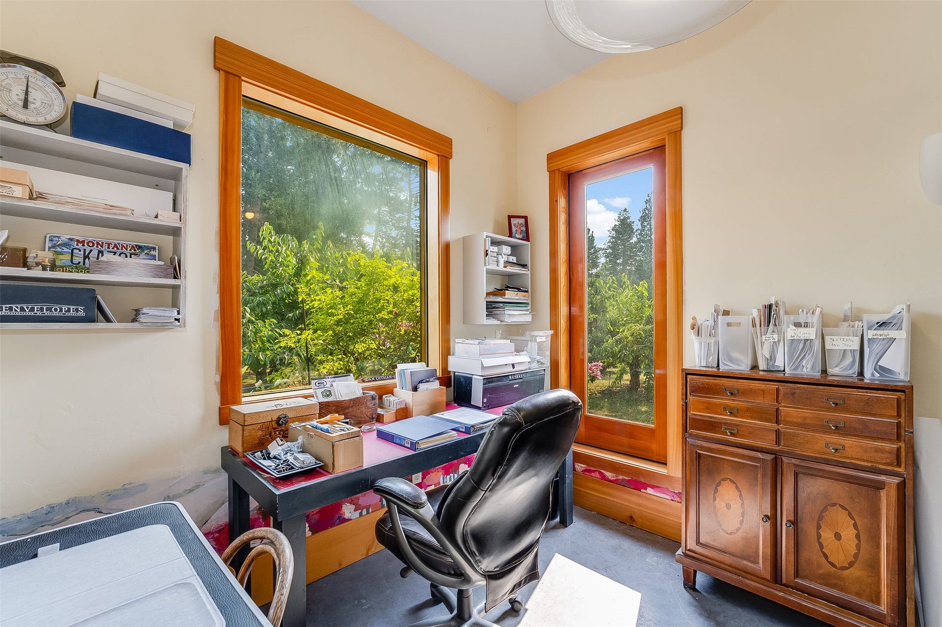 21848 Mt Highway 35, Bigfork, MT 59911 Ground level office featuring a large picture window and a full-light door with wood trim, built-in shelving, and light-toned walls. Separate outside entrance.