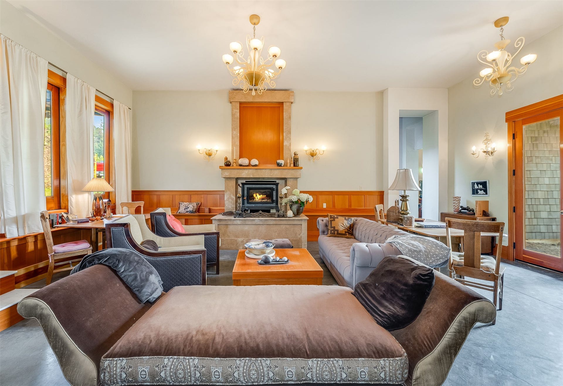 21848 Mt Highway 35, Bigfork, MT 59911 Living area featuring a stone-clad fireplace with an insert, wood paneling, and an exposed wood door with glass panes