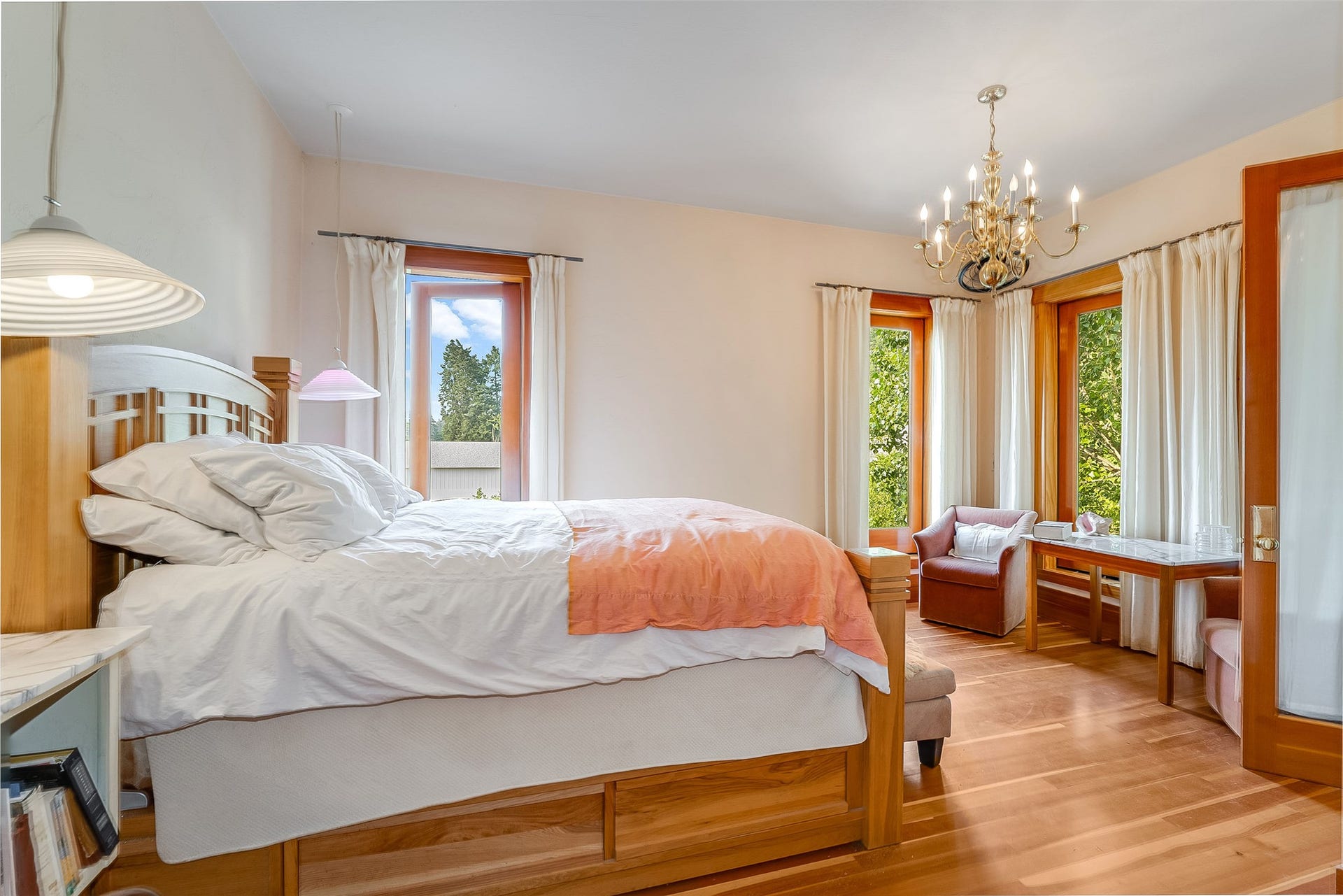 21848 Mt Highway 35, Bigfork, MT 59911 Bright interior space featuring light wood-finish flooring, multiple windows with wood trim, and a brass chandelier