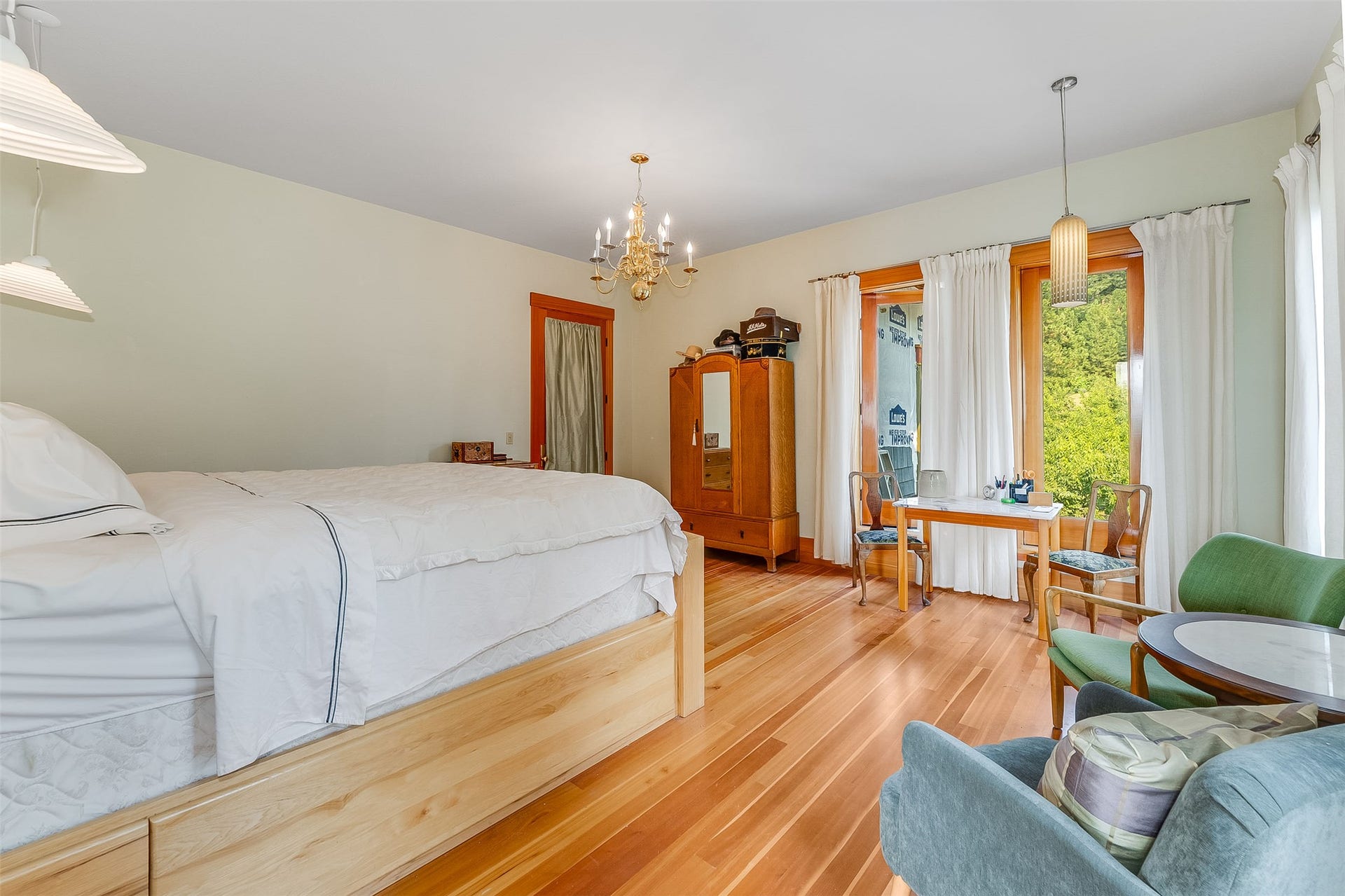 21848 Mt Highway 35, Bigfork, MT 59911 Spacious room featuring wood-finish flooring, a brass chandelier, and light-toned walls