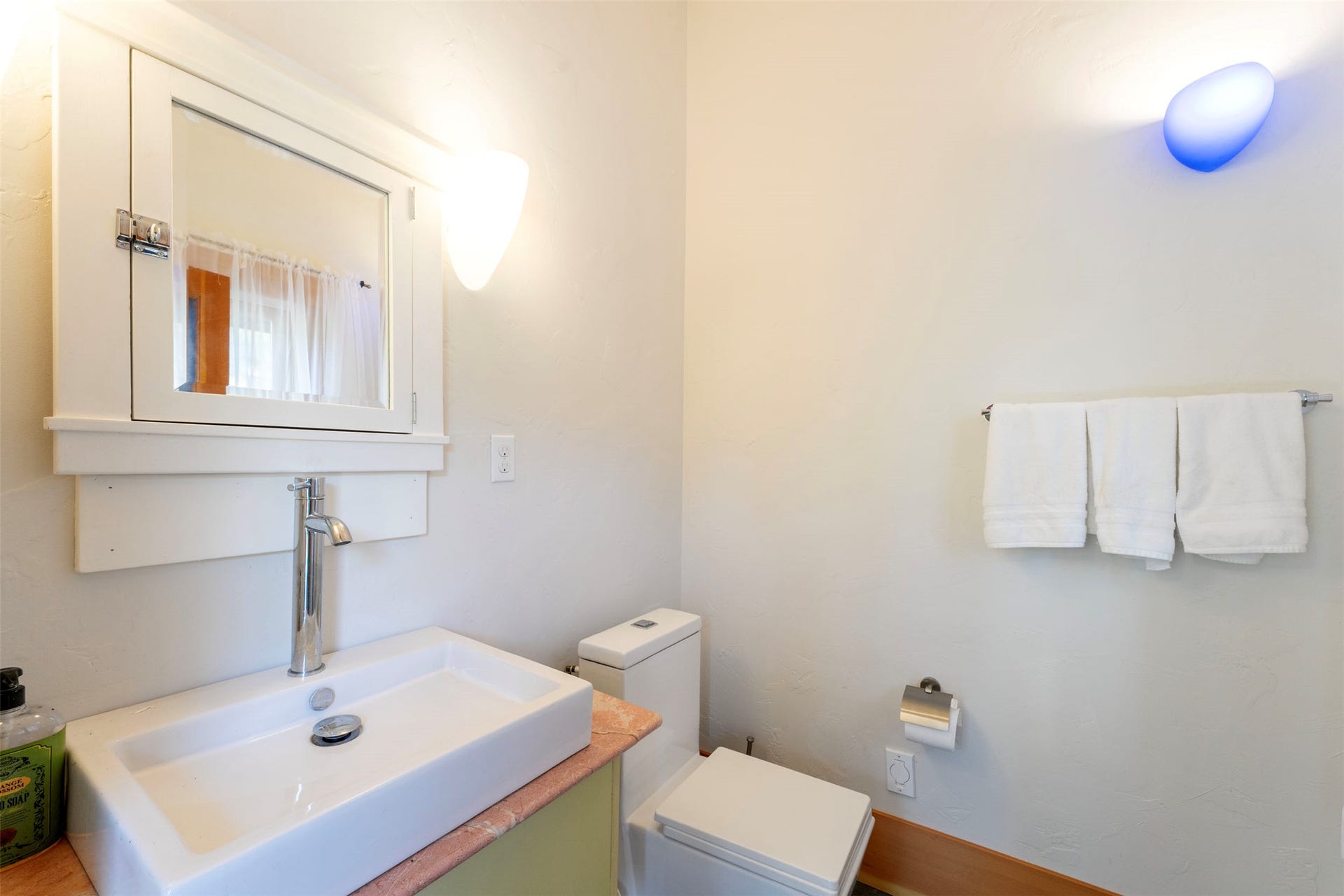 21848 Mt Highway 35, Bigfork, MT 59911 Bathroom featuring a vessel sink with a tall chrome faucet, a medicine cabinet with mirror, a toilet, and wall-mounted towel bar