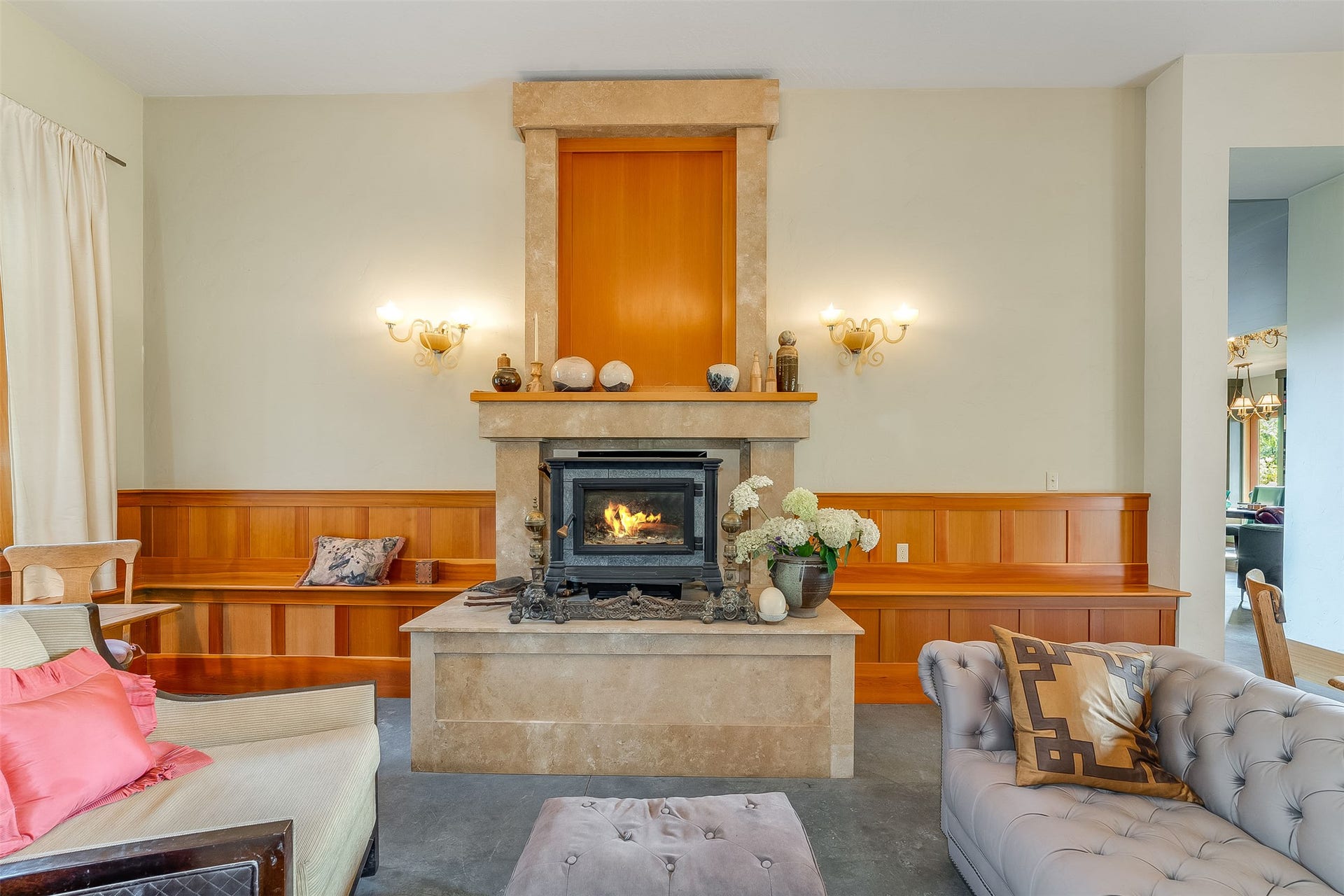 21848 Mt Highway 35, Bigfork, MT 59911 Central stone fireplace with an integrated wood stove, flanked by built-in wood paneling benches.