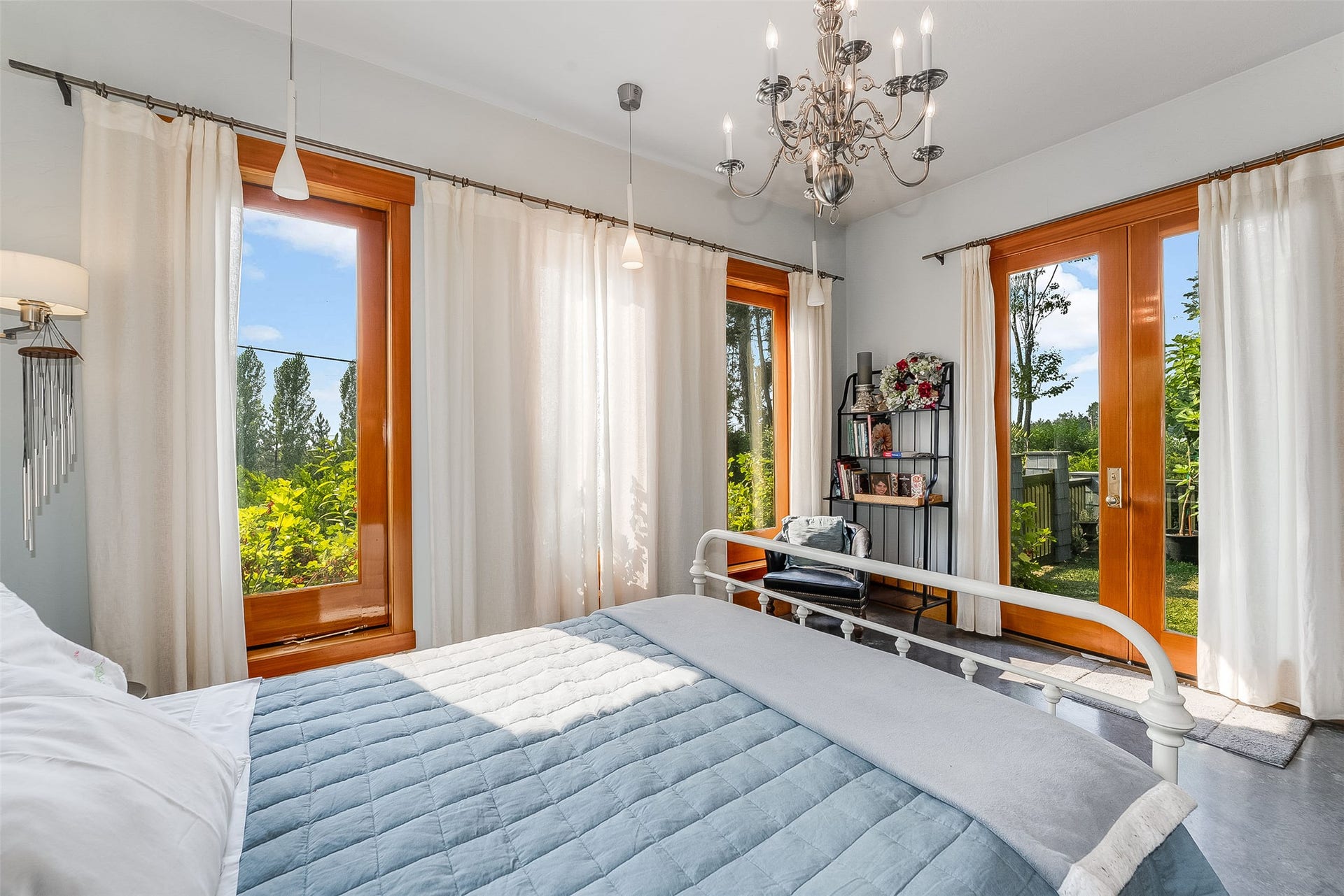21848 Mt Highway 35, Bigfork, MT 59911 Spacious guest bed room featuring multiple wood-framed windows and French doors, a decorative chandelier, and light-colored walls